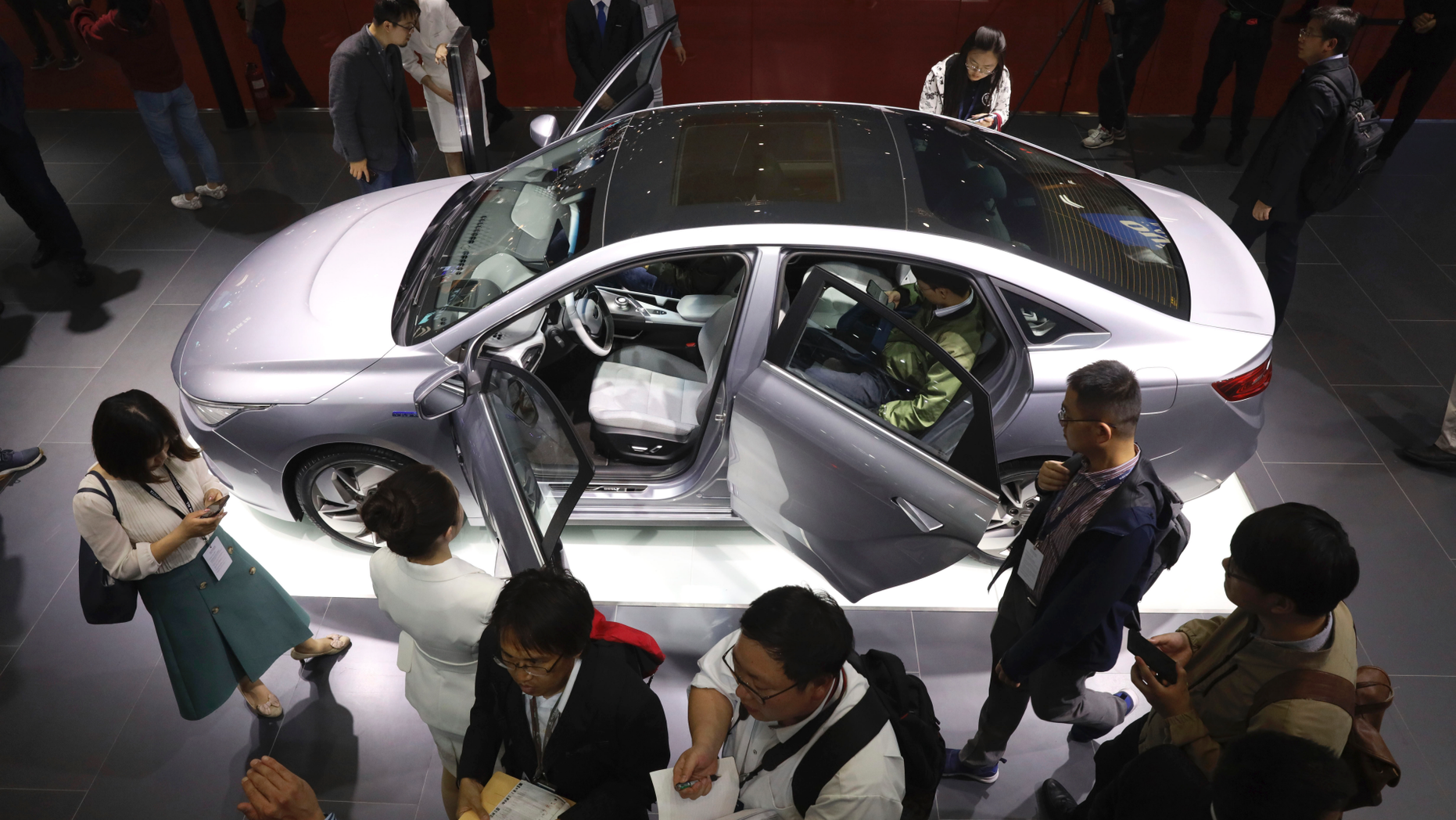 FILE - In this April 16, 2019, file photo, Chinese automaker Geely Auto displays a sedan from its new electric brand Geometry during the Auto Shanghai 2019 show in Shanghai. China's auto sales sank 17.7% in April from a year earlier, the 10th straight month of decline amid trade tension with Washington and an economic slowdown. (AP Photo/Ng Han Guan, File)