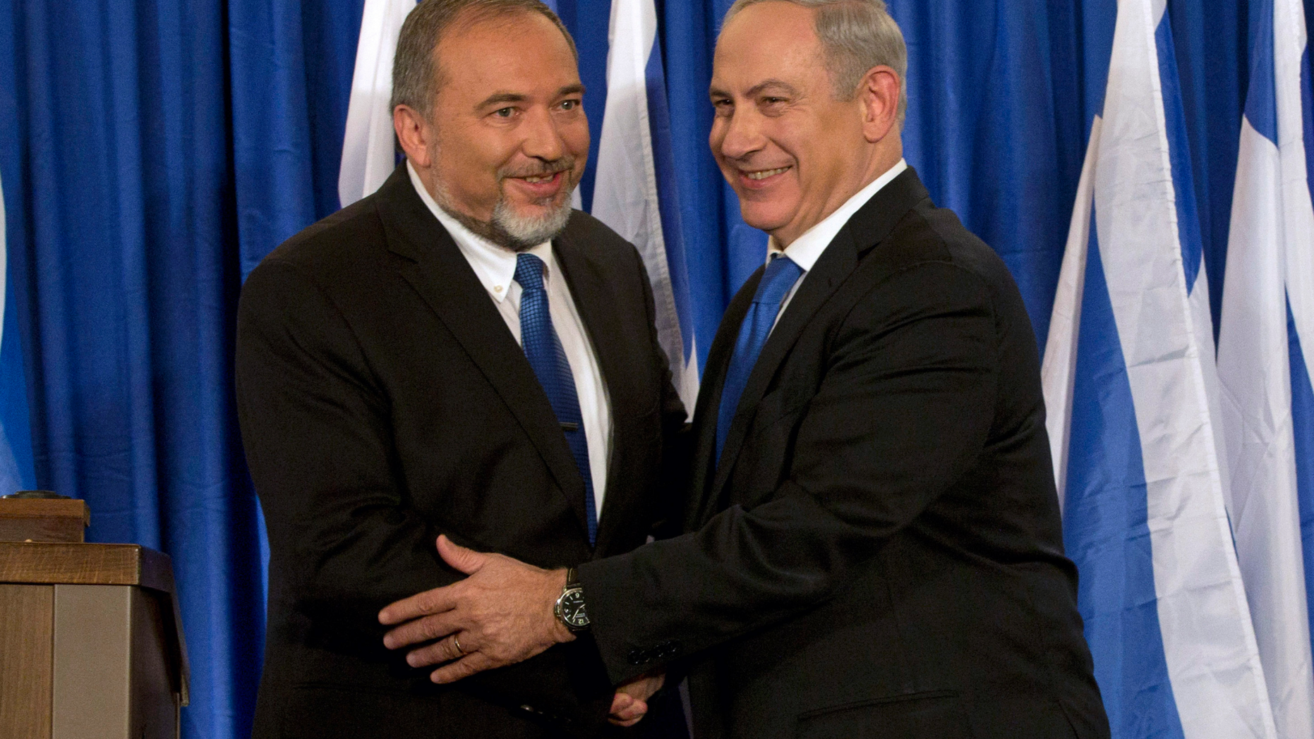 FILE - In this Oct. 25, 2012 file photo, Israeli Prime Minister Benjamin Netanyahu, right, and former Israeli Defense Minister Avigdor Lieberman shake hands in front of the media after giving a statement in Jerusalem. Netanyahu is facing the possibility of having to fight a second election this year, as he struggles to form a coalition government. With a looming deadline, Israel's newly elected parliament began drafting a bill on Monday to dissolve itself. (AP Photo/Bernat Armangue, File)