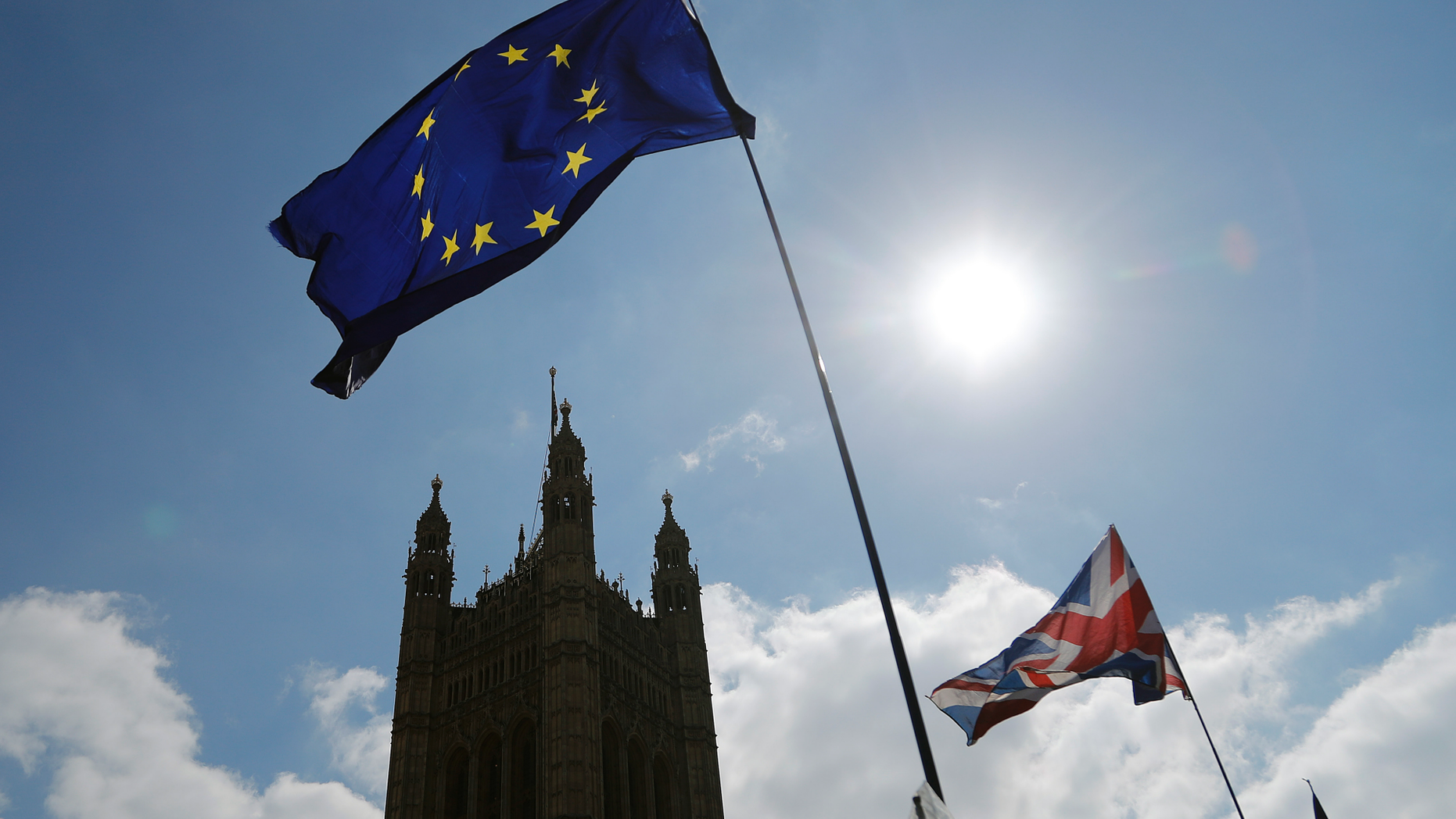 FILE - In this Thursday, April 11, 2019 file photo, protestor flags fly opposite the Houses of Parliament in London. The British economy is likely to weaken as firms stop ease up on Brexit preparations now that Britain’s departure from the European Union has been delayed by months, the Bank of England said Thursday, May 2, 2019. (AP Photo/Frank Augstein, File)