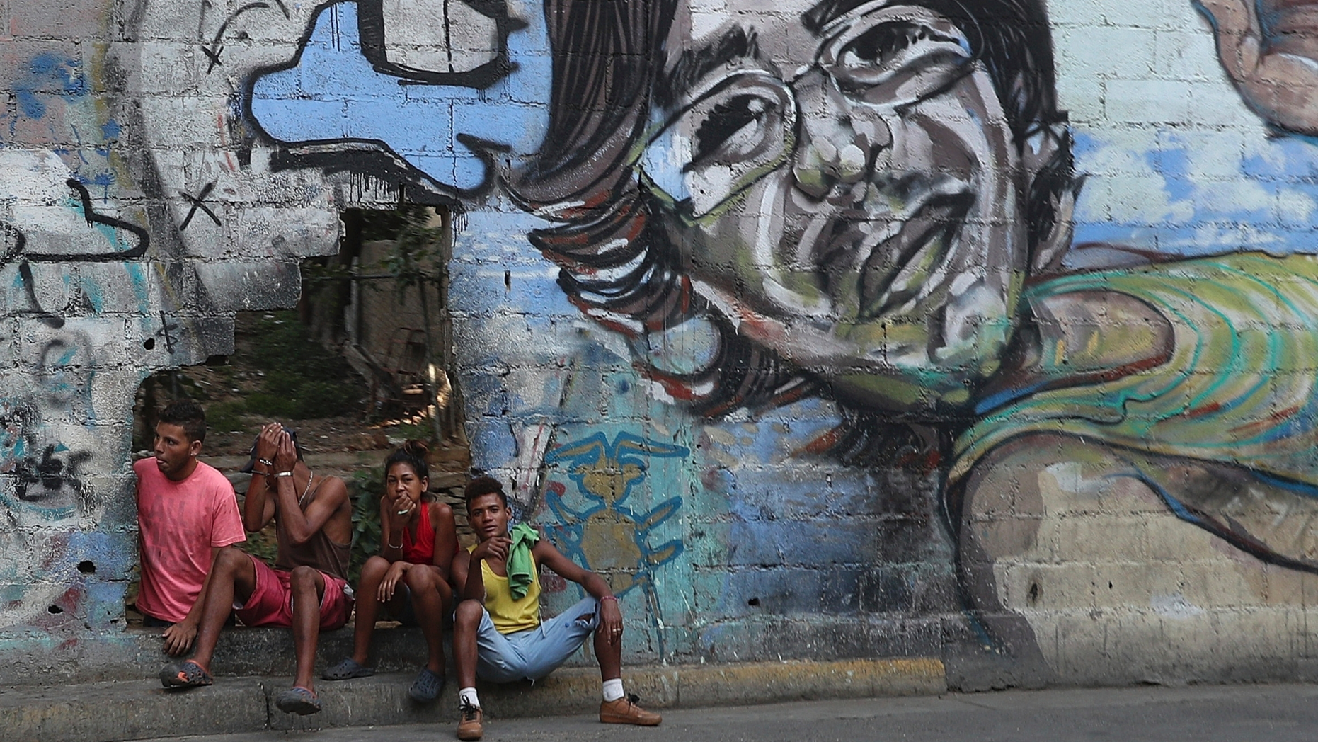 A group of young people rest in a hole in the wall at the Agua Salud neighborhood of Caracas, Venezuela, Wednesday, May 15, 2019. More than 3 million Venezuelans have left their homeland in recent years amid skyrocketing inflation and shortages of food and medicine. U.S. administration officials have warned that 2 million more are expected to flee by the end of the year if the crisis continues in the oil-rich nation. (AP Photo/Martin Mejia)
