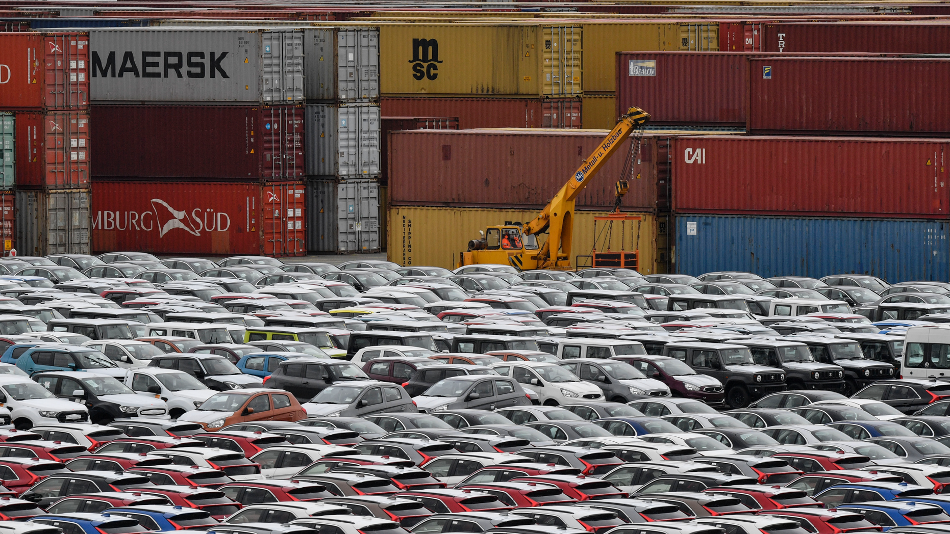 Cars for export and import are stored in front of containers on Thursday, May 16, 2019 at the harbor in Bremerhaven, Germany, with 2 million vehicles per annum one of the largest automobile hubs in the world. US President Donald Trump is delaying any decision to impose tariffs on car and auto-part imports for now. (AP Photo/Martin Meissner)