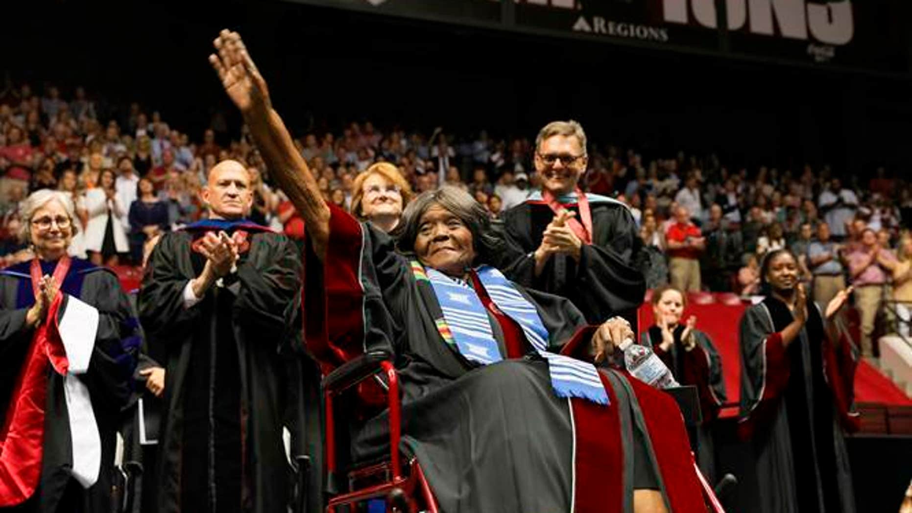 This photo provided by UA Strategic Communications, Ms. Lucy Foster, thanks the crowd for receiving an honorary doctorate at a launch exercise at the University of Alabama on Friday, May 3, 2019 in Tuscaloosa, Alabama . The university awarded the honorary doctorate in Foster, the first African-American to attend university. (Zach Riggins / AU Strategic Communications via AP)