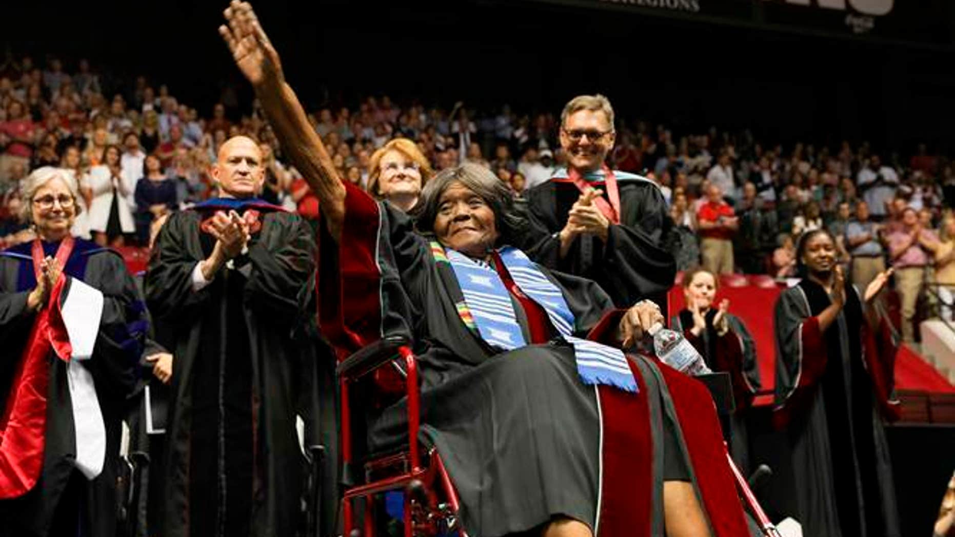 This photo provided by UA Strategic Communications Autherine Lucy Foster acknowledges the crowd as she receives a an honorary doctoral degree during a commencement exercise at The University of Alabama on Friday, May 3, 2019 in Tuscaloosa, Ala. The university bestowed the honorary doctorate degree to Foster, the first African American to attend the university. (Zach Riggins/UA Strategic Communications via AP)