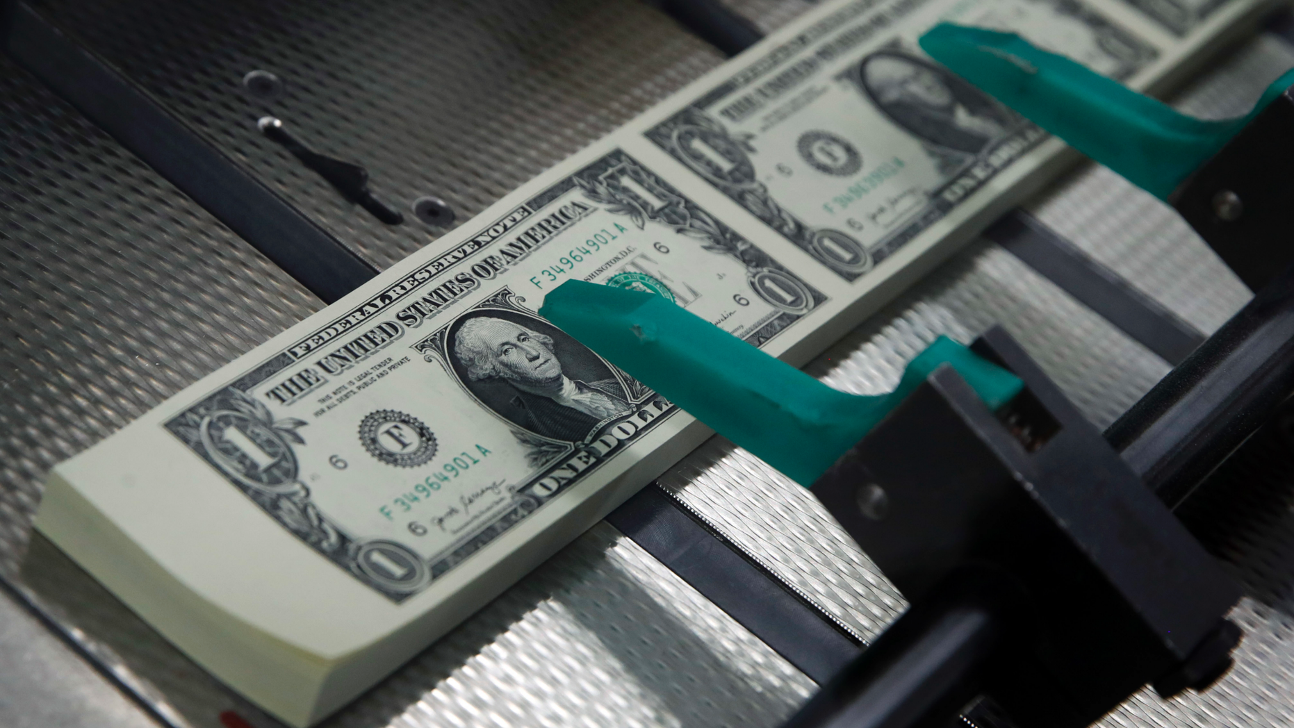 FILE- In this Nov. 15, 2017, file photo, new $1 bills with the signatures of U.S. Treasurer Jovita Carranza and Treasury Secretary Steven Mnuchin are cut and stacked at the Bureau of Engraving and Printing in Washington. Last year’s scary tumble for the stock market wasn’t enough to scare workers off of saving for retirement. Instead, many ended up saving more. During the first quarter of this year, the average worker set aside a record $2,370, according to Fidelity Investments. Including employer contributions, workers saved an average of 13.5% of their pay during the first three months of 2019. That’s the closest they’ve ever come to Fidelity’s recommendation of 15%. (AP Photo/Jacquelyn Martin, File)