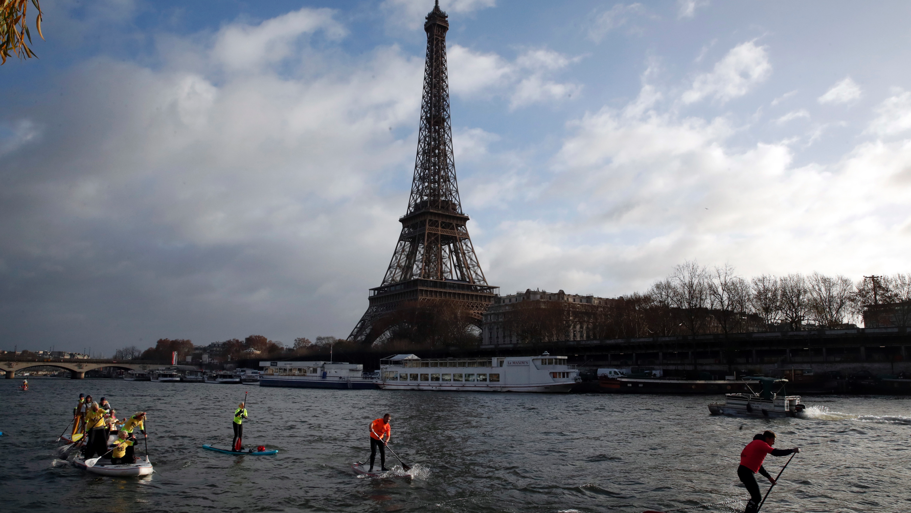 FILE - In this Dec.9, 2018 file photo, competitors paddle on the Seine river in front of the Eiffel Tower in Paris. The Eiffel Tower press office said Monday May 20, 2019 an unidentified individual tried to scale the near-300 meter (near-328 yard) monument on Monday afternoon but it wasn't clear how high the climber managed to get. (AP Photo/Christophe Ena, File)