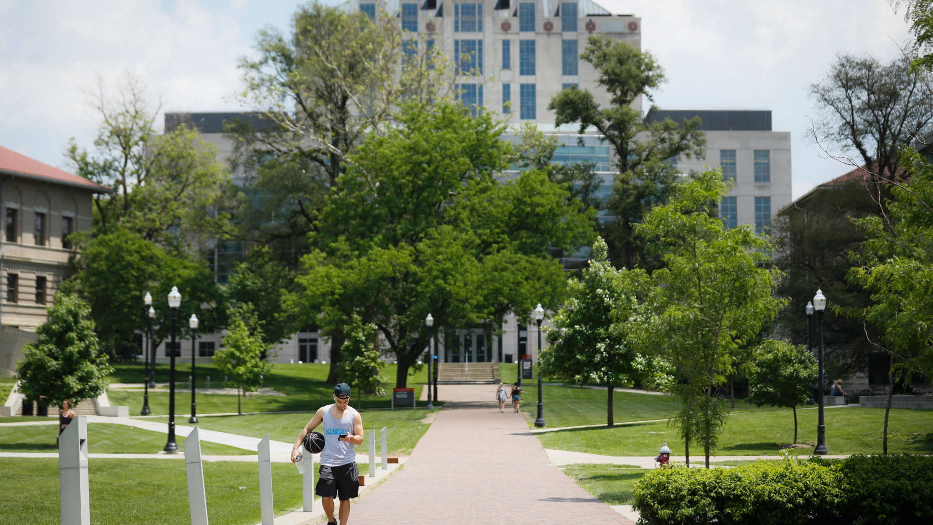 Pedestrians walk towards The Ohio State University's athletics facilities, Saturday, May 18, 2019, in Columbus, Ohio. Dr. Richard Strauss, a now-dead Ohio State team doctor sexually abused at least 177 male students from the 1970s through the 1990s, and numerous university officials got wind of what was going on over the years but did little or nothing to stop him, according to a report released by the school Friday. (AP Photo/John Minchillo)