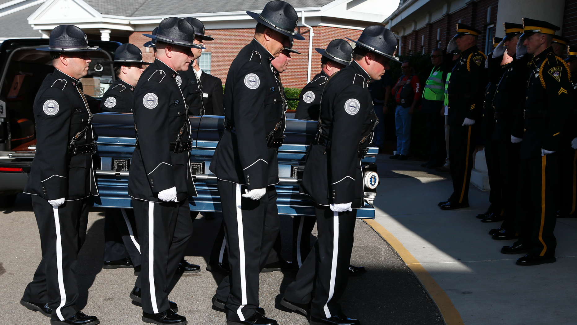Members of the Biloxi Police Department Honor Guard escort the body of officer Robert McKeithen, into the First Baptist Church of Biloxi, Miss., Monday, May 13, 2019, for visitation. McKeithen was killed outside Biloxi's police station May 5. (AP Photo/Rogelio V. Solis)
