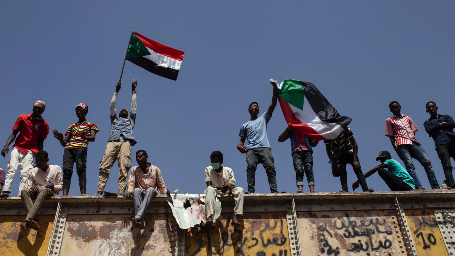 Sudanese protesters wave national flags at the sit-in outside the military headquarters, in Khartoum, Sudan, Thursday, May 2, 2019. Sudan's protesters are holding a mass rally to step up pressure on the military to hand power to civilians following last month's overthrow of President Omar al-Bashir. (AP Photos/Salih Basheer)