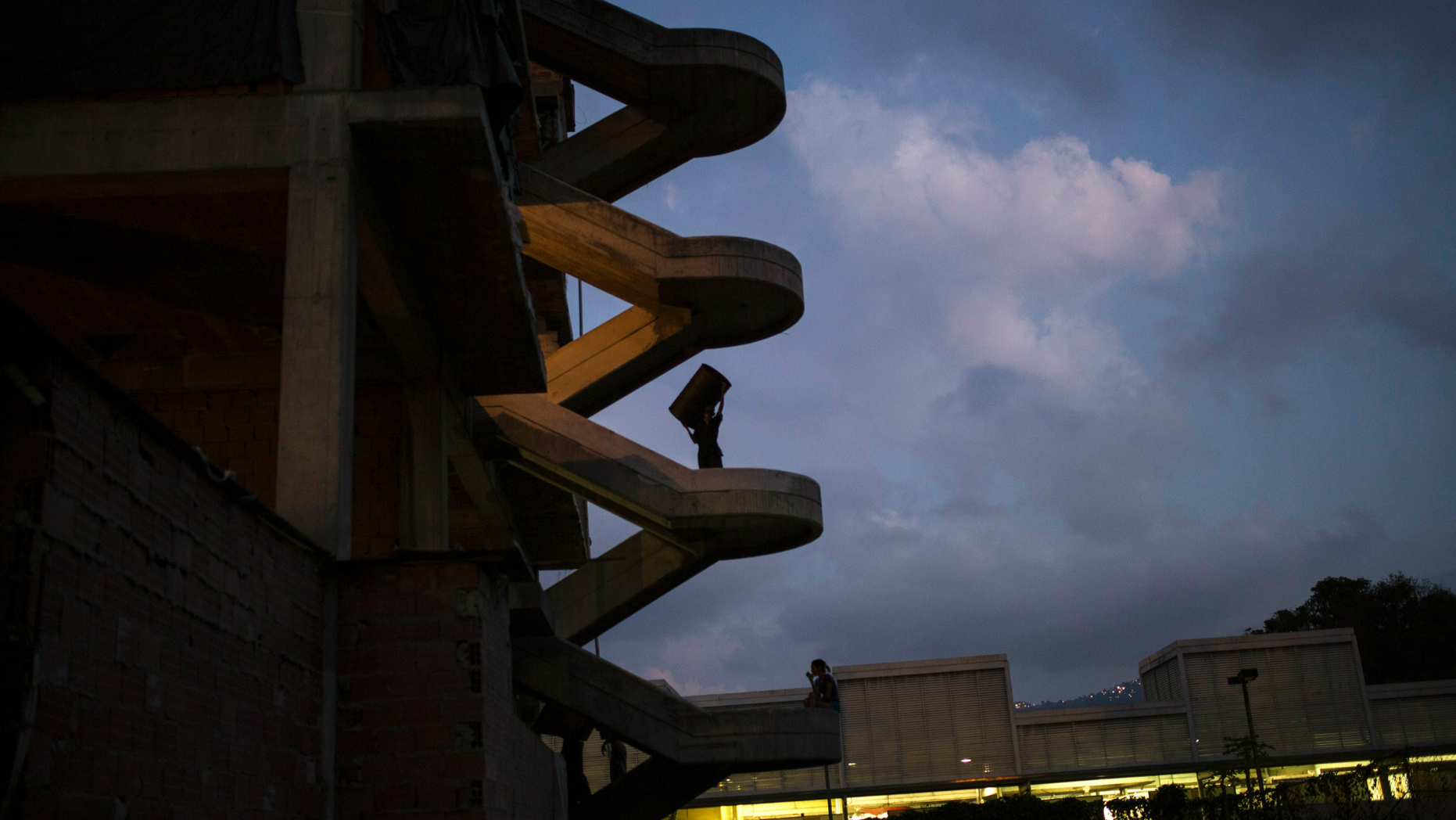 A man carries a barrel inside a building occupied by squatting families in Caracas, Venezuela, Tuesday, May 7, 2019. Venezuela is in the midst of a growing political and economic crisis as, the U.S.-backed Juan Guaidó declared himself interim president in January, saying President Nicolas Maduro's re-election last year was rigged and one in a series of increasingly authoritarian steps since he replaced the late Hugo Chávez in 2013 as president. (AP Photo/Rodrigo Abd)
