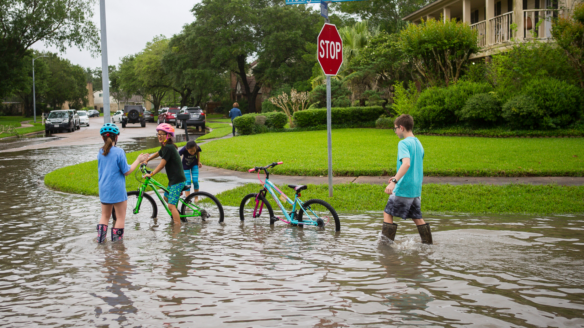 Children play in the Colony Bend neighborhood of Sugar Land, Texas, on Wednesday, May 8, 2019. Residents have been surprised that the water has not receded more quickly as it has in the past when the rain has stopped. More rain is forecast for the coming days. (Mark Mulligan/Houston Chronicle via AP)