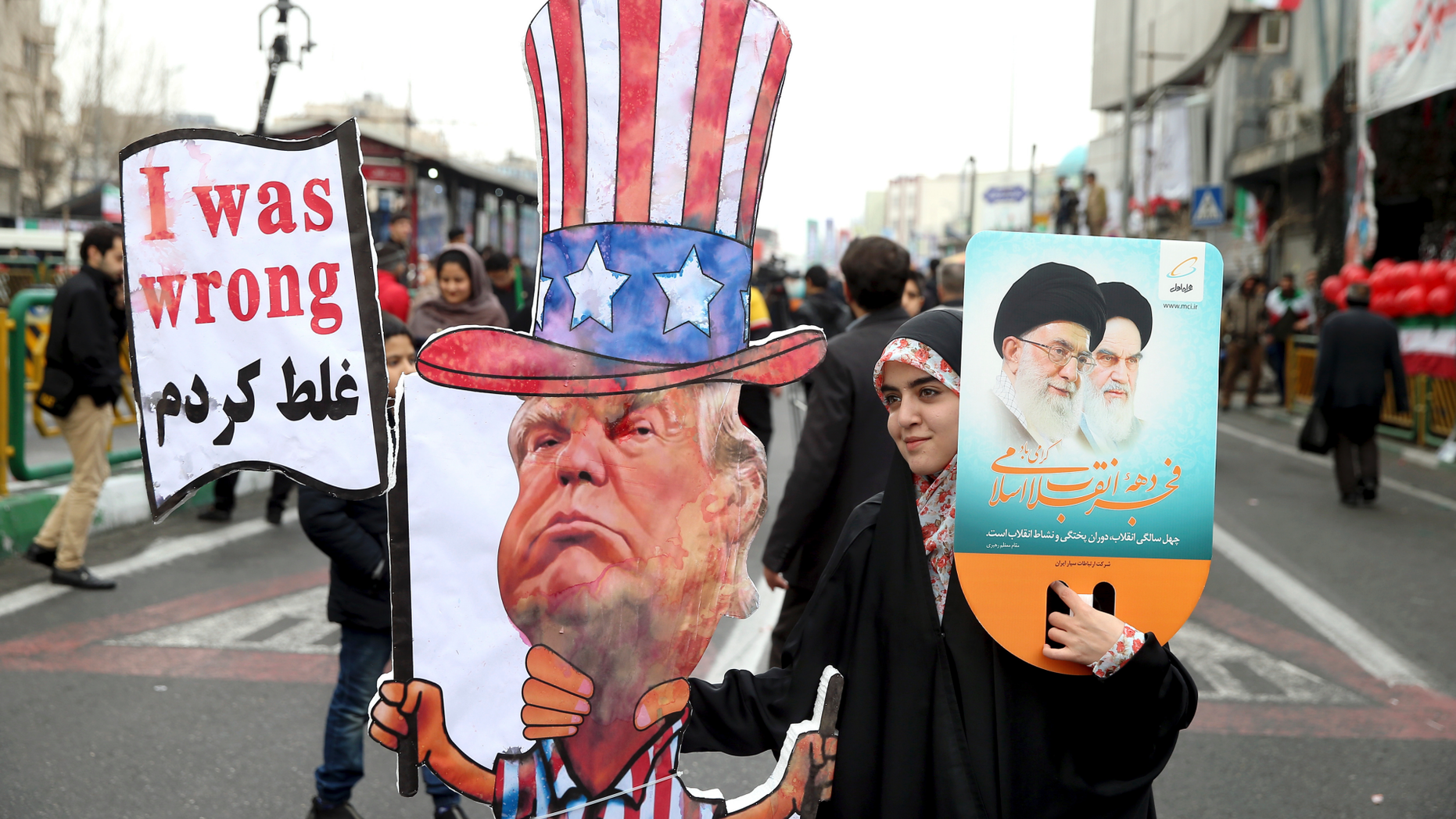 FILE - In a Feb. 11, 2019 file photo, an Iranian woman holds an effigy of US president Donald Trump, during a rally marking the 40th anniversary of the 1979 Islamic Revolution, in Tehran, Iran. Iranian President Hassan Rouhani is reportedly set to announce Wednesday, May 8, 2019, ways the Islamic Republic will react to continued U.S. pressure after President Donald Trump pulled America from Tehran’s nuclear deal with world powers. (AP Photo/Ebrahim Noroozi, File)