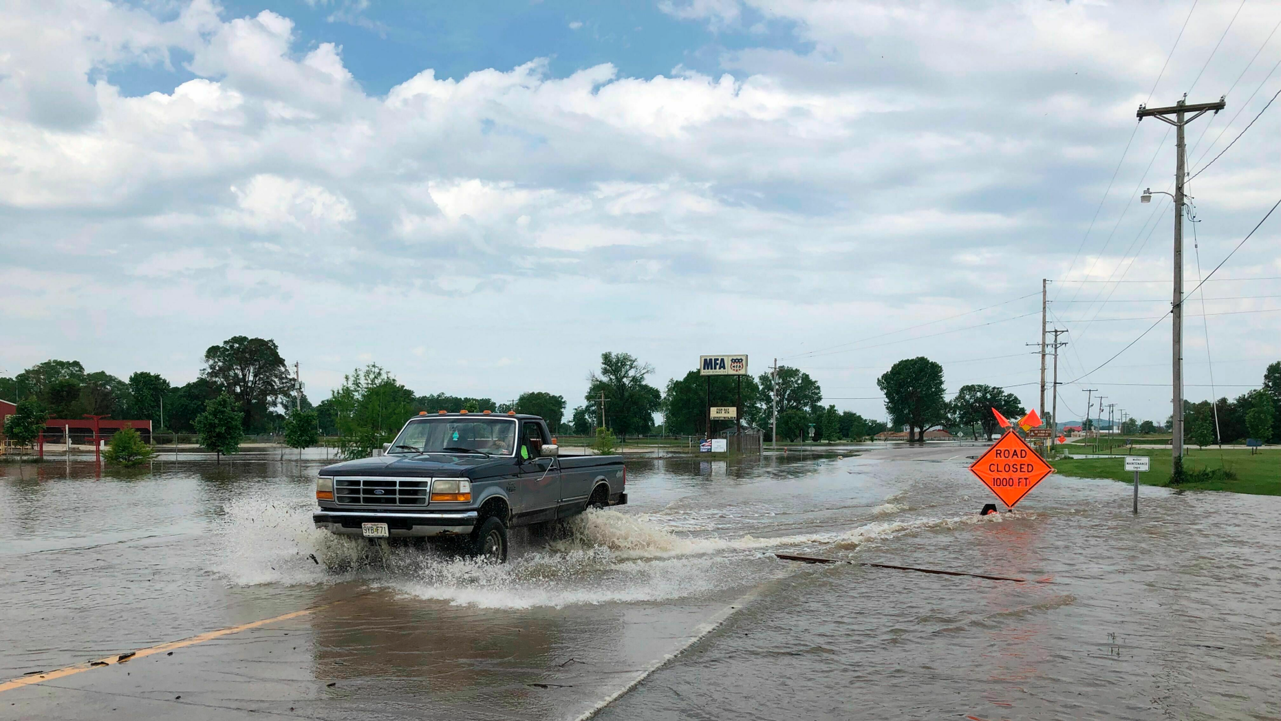 A pickup truck evacuates from an area north of Jefferson City, Missouri, while the waters of the Missouri River rise on the road on Friday, May 24, 2019. Floods occur as residents still clean up a powerful tornado who hit the state capital May 22nd. (AP Photo / David A. Lieb)