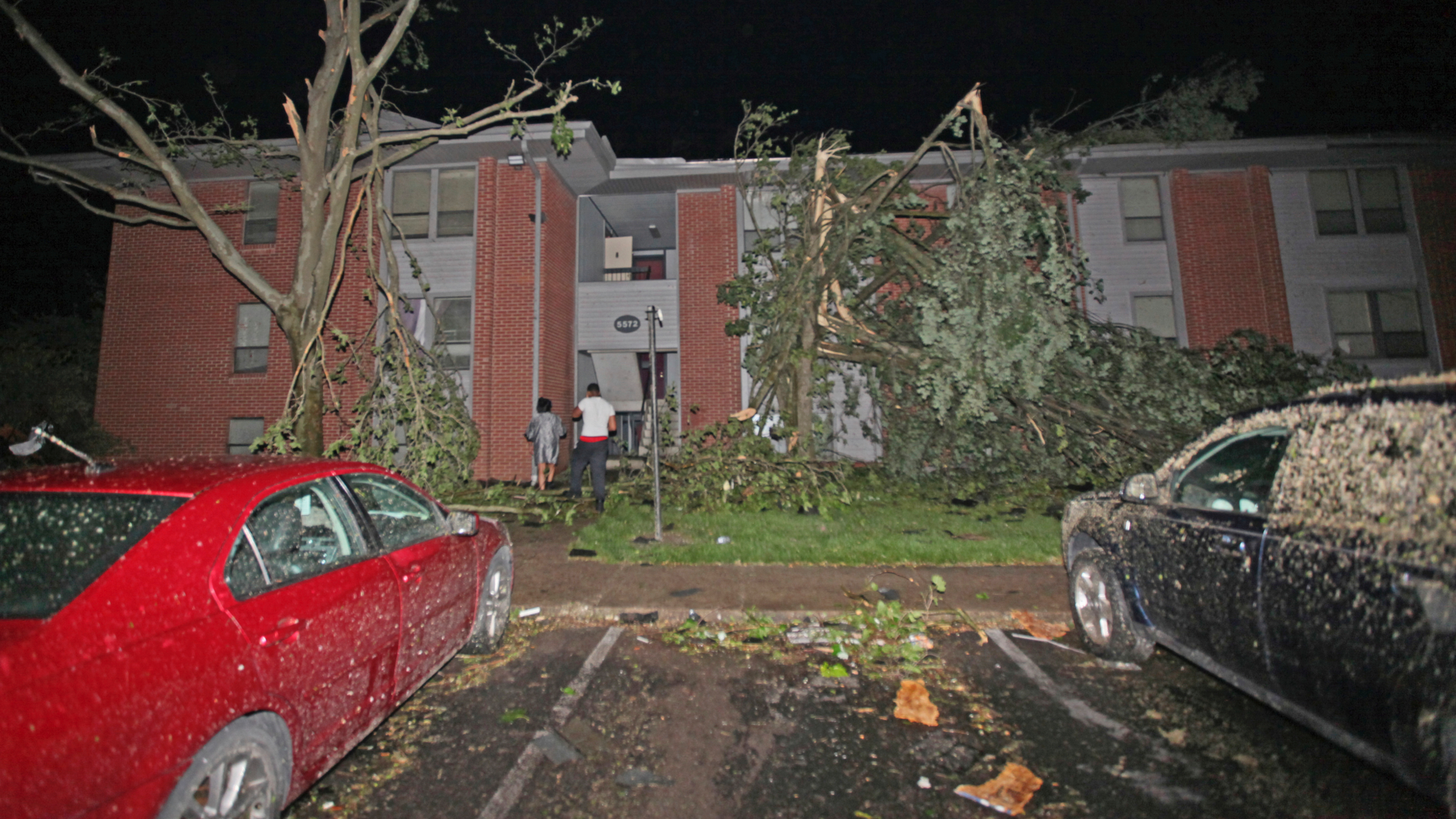 Residents walk toward their Westbrooke Village Apartment building that was heavily damaged by a tornado Tuesday morning, May 28, 2019, in Dayton, Ohio. The Ohio Department of Transportation is using snow plows to remove debris off an Ohio highway after a "large and dangerous" tornado hit the area late Monday. (Doral Chenoweth III/Columbus Dispatch via AP)