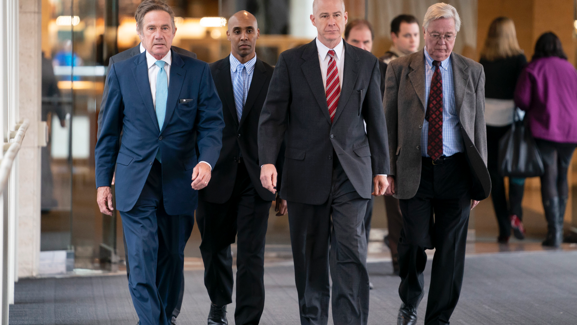 Former Minneapolis police officer Mohamed Noor, center left, walks into the Hennepin County Courthouse for the verdict in the shooting death of Justine Ruszczyk Damond with his lawyers Peter Wold, left, and Thomas Plunkett, right, in Minneapolis, on Tuesday, April 30, 2019. Noor was convicted later of third-degree murder Tuesday in the fatal shooting of the unarmed woman who approached his squad car minutes after calling 911 to report a possible rape behind her home. (Renee Jones Schneider/Star Tribune via AP)