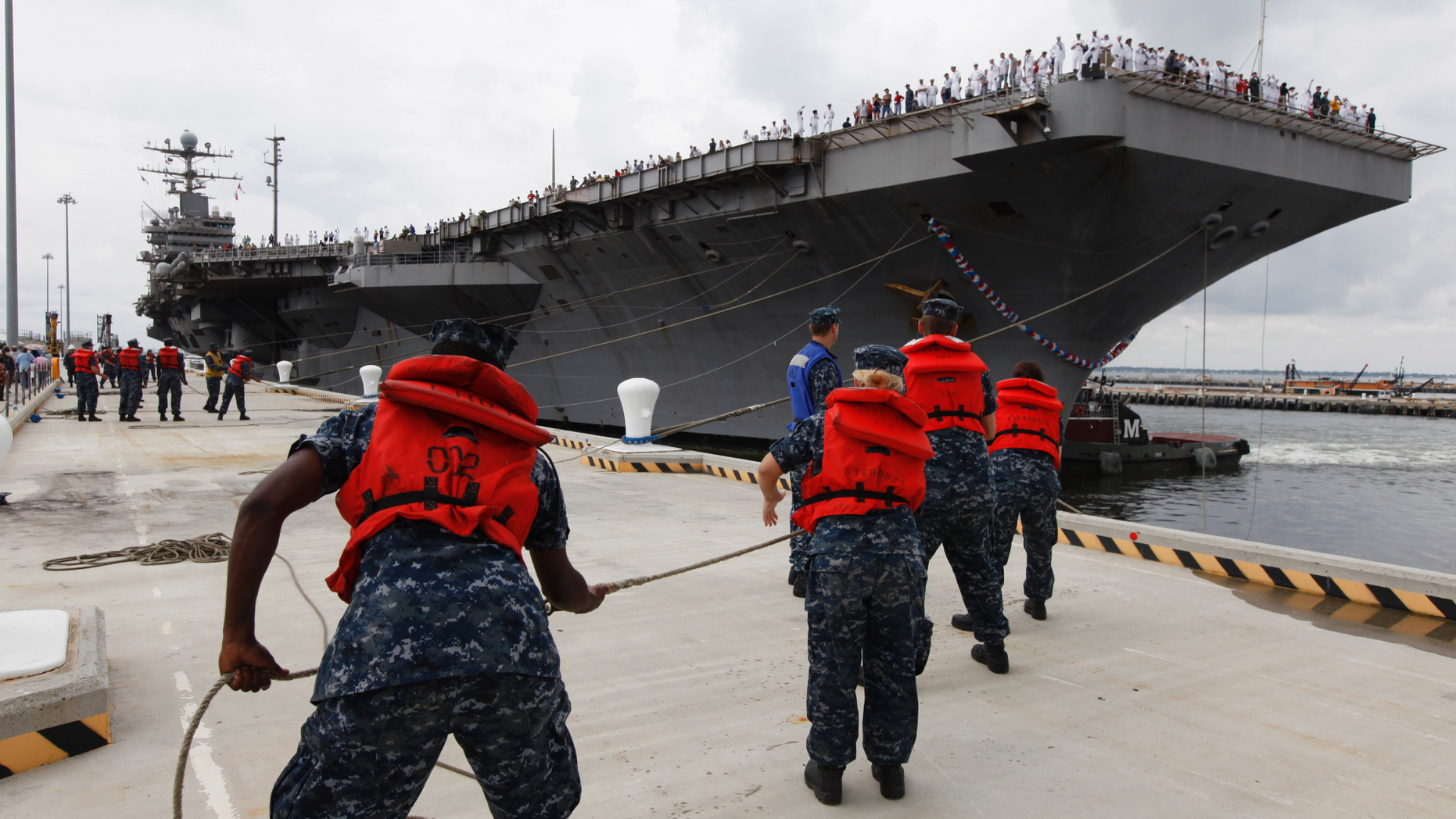 FILE - In this Aug. 7, 2012, file photo, Navy shore crew haul in lines as the nuclear powered aircraft carrier USS Abraham Lincoln arrives at Naval Station Norfolk in Norfolk, Va. The U.S. is dispatching the USS Abraham Lincoln and other military resources to the Middle East following “clear indications” that Iran and its proxy forces were preparing to possibly attack U.S. forces in the region, according to a defense official on May 5, 2019. (AP Photo/Steve Helber, File)
