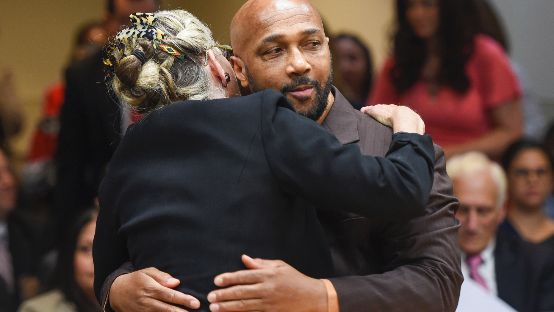 Keith Bush is embraced by his attorney, Adele Bernhard, Wednesday, May 22, 2019 at Suffolk County Courthouse in Riverhead, N.Y. after murder charges against him were vacated. Bush, who spent 33 years in prison for the 1975 murder of a high school classmate, had his conviction overturned Wednesday after a case review found Long Island prosecutors had long hid the fact that police looked at another possible suspect. (James Carbone/Newsday via AP, Pool)