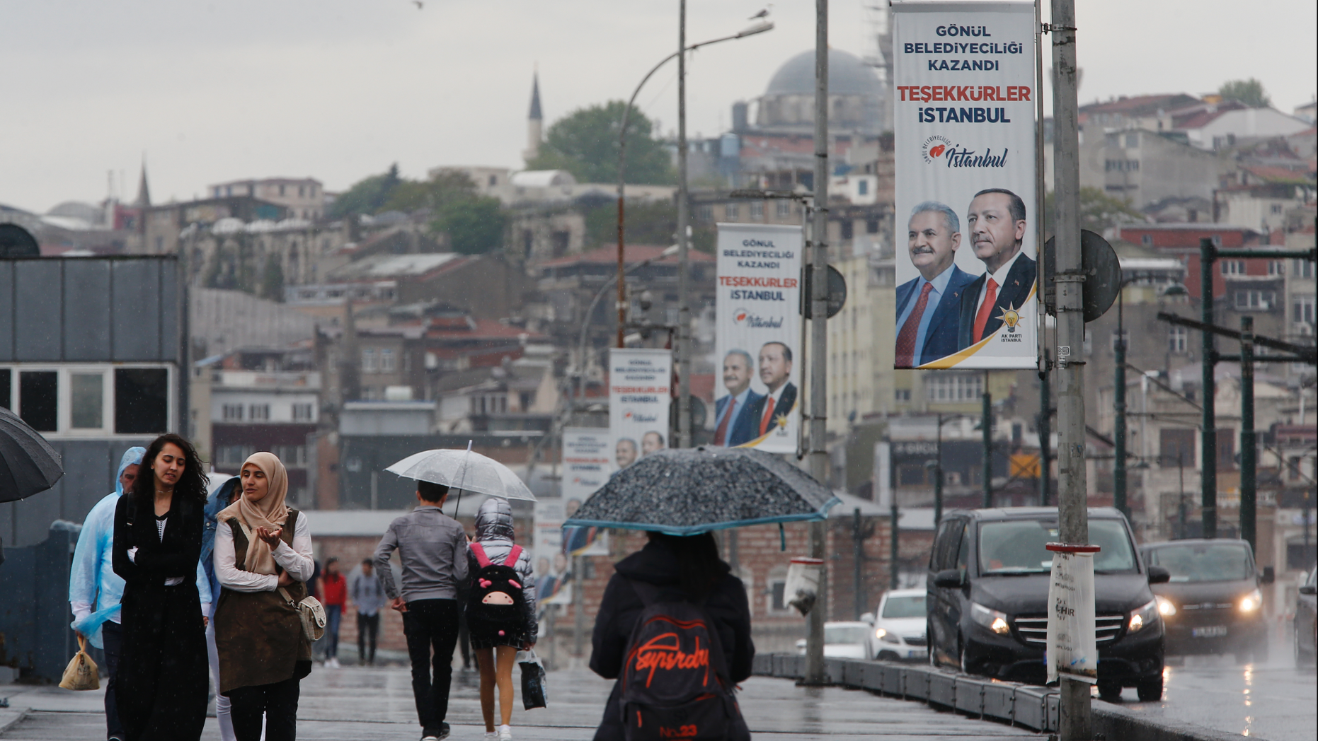 People walk on Galata Bridge over the Golden Horn in Istanbul, decorated with electoral posters of Turkey's President Recep Tayyip Erdogan and his party's Istanbul mayoral candidate Binali Yildirim, Tuesday, May 7, 2019. Ruling in favor of Erdogan's governing party, Turkey's top electoral body on Monday annulled the results of the March 31 vote in Istanbul which the opposition candidate Ekrem Imamoglu narrowly won and scheduled a re-run for June 23.Erdogan insisted Tuesday that the repeat of the mayoral race in Istanbul will strengthen democracy and lift the shadow that was cast over the vote.(AP Photo/Lefteris Pitarakis)