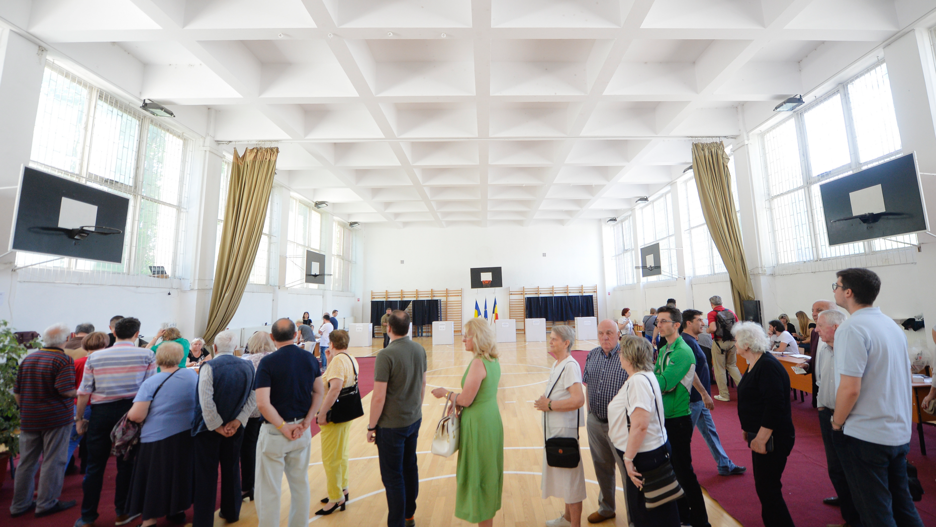 People wait in line to cast their vote as a higher than usual voter turnout is registered shortly after noon at 19.75 percent in Bucharest, Romania, Sunday, May 26, 2019. Romanians vote in the European Parliament elections and a referendum called by Iohannis on judicial system laws.(AP Photo/Andreea Alexandru)