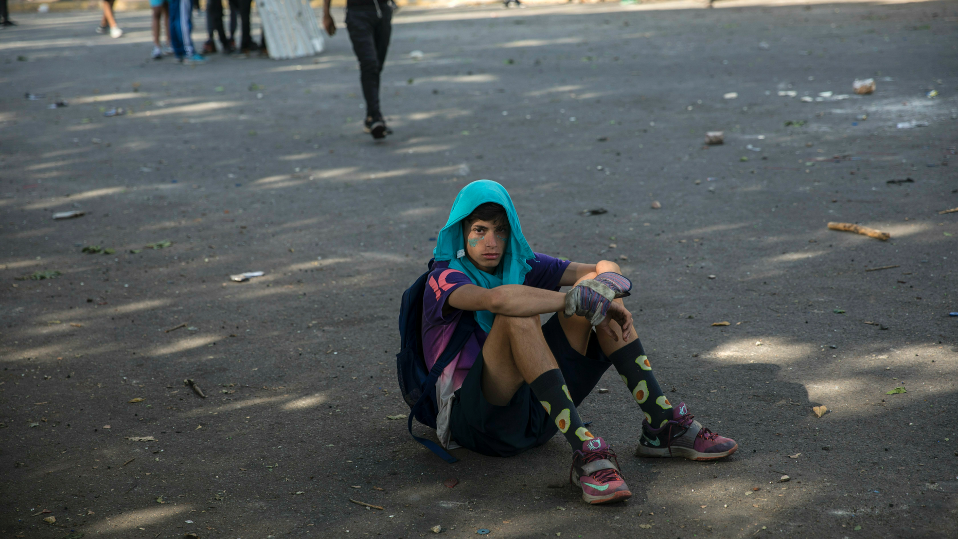 An anti-government protester rests during clashes with National Guard forces near La Carlota airbase in Caracas, Venezuela, Wednesday, May 1, 2019. Opposition leader Juan Guaido called for Venezuelans to fill streets around the country Wednesday to demand President Nicolas Maduro's ouster. Maduro is also calling for his supporters to rally. (AP Photo/Rodrigo Abd)