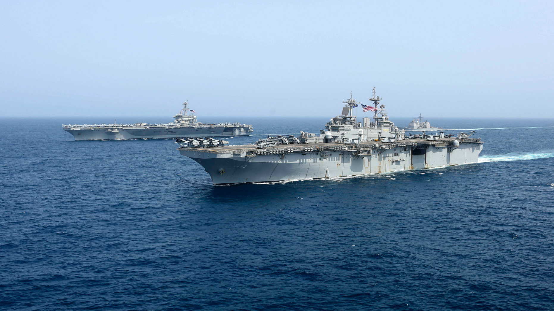 CORRECTS DATE - In this Friday, May 17, 2019, photo released by the U.S. Navy, the amphibious assault ship USS Kearsarge sails in front of the USS Abraham Lincoln aircraft carrier in the Arabian Sea. Commercial airliners flying over the Persian Gulf risk being targeted by "miscalculation or misidentification" from the Iranian military amid heightened tensions between the Islamic Republic and the U.S., American diplomats warned Saturday, May 18, 2019, even as both Washington and Tehran say they don't seek war. (Mass Communication Specialist 1st Class Brian M. Wilbur, U.S. Navy via AP)