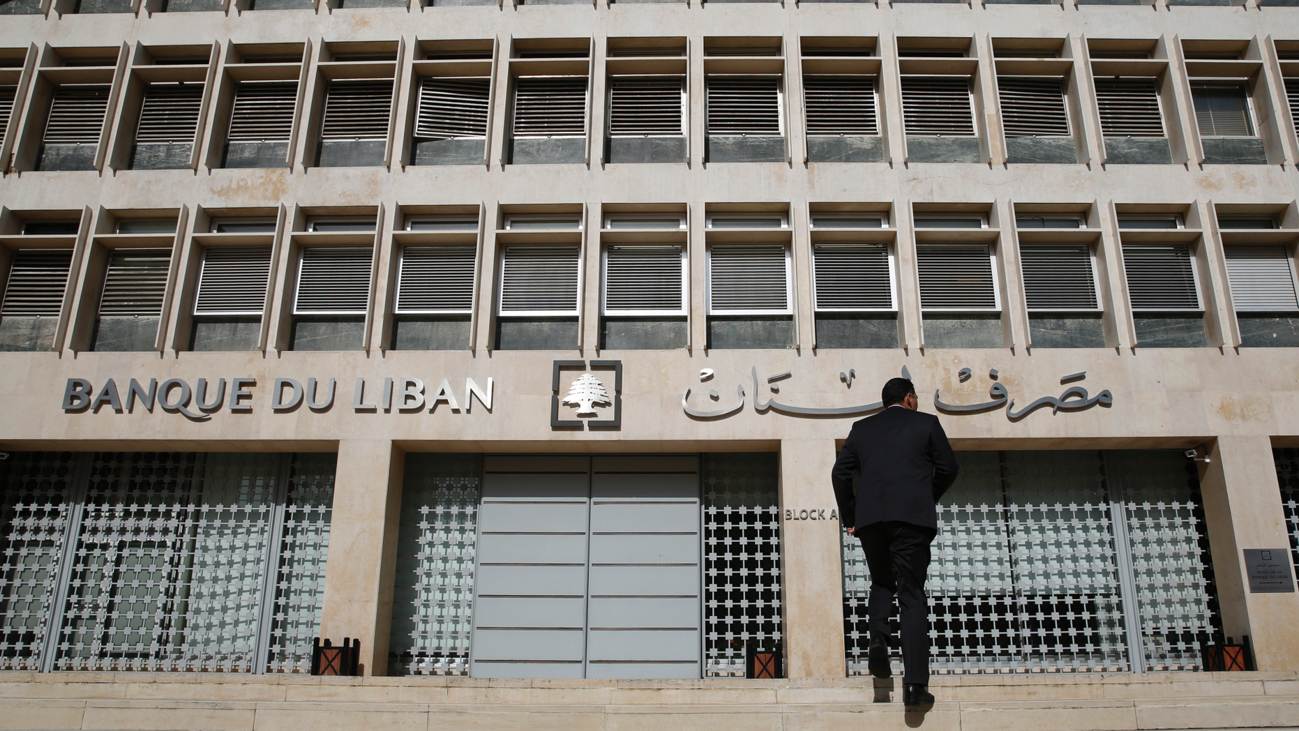 FILE - This Tuesday, Jan. 22, 2019 file photo, a man heads to the Lebanese central bank, in Beirut, Lebanon. The Beirut Stock Exchange said Monday, May 6, 2019, that it is suspending trading due to the open strike declared by the employees of Lebanon's central bank. Hundreds of Lebanese public employees are on strike amid concerns that their salaries and benefits might be cut as the government discusses an austerity budget. (AP Photo/Hussein Malla, File)