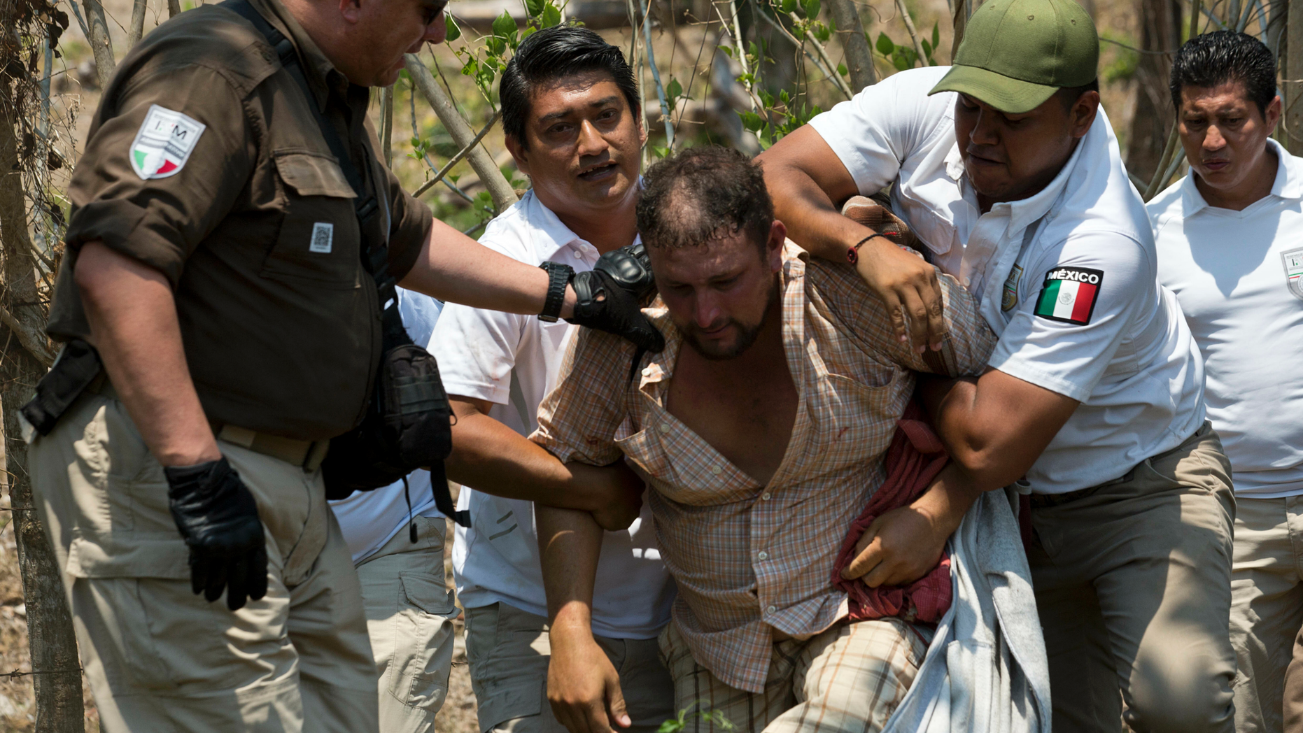 FILE - In this April 22, 2019 file photo, a Central American migrant is detained by Mexican immigration agents on the highway to Pijijiapan, Mexico. Mexican authorities say the number of mainly Central American migrants who were detained in April has risen by 79% in comparison to the same month last year, according to figures released by Mexico's Interior Department on Thursday, May 10, 2019. (AP Photo/Moises Castillo, File)