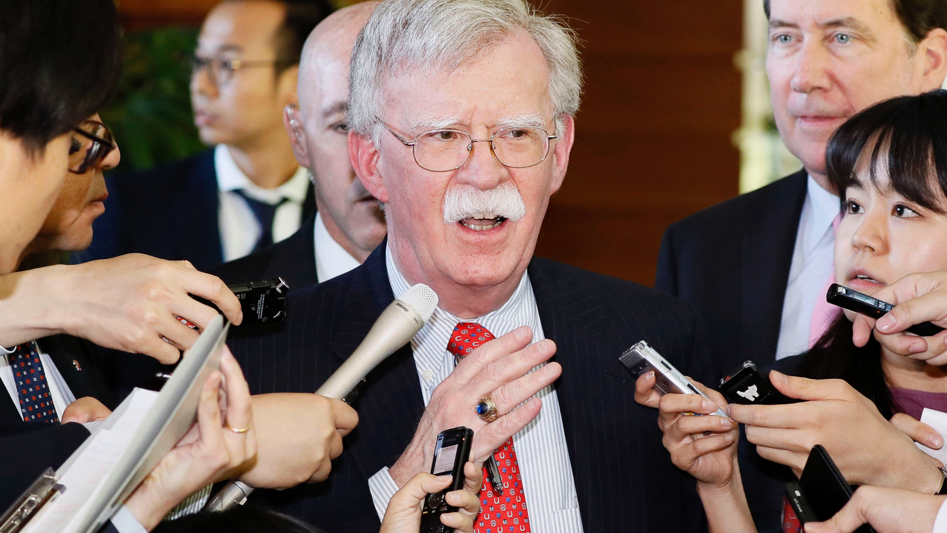 In this Friday, May 24, 2019, photo, U.S. National Security Adviser John Bolton is surrounded by reporters at the prime minister's official residence in Tokyo. Bolton called a series of short-range missiles launched by North Korea last month were violations to U.N. Security Council resolutions, stressing the need to keep sanctions in place. Bolton said Saturday, May 25, 2019, in Tokyo the U.S. position on the North’s denuclearization is consistent and that a repeated pattern of failures should be stopped. (Yohei Kanasashi/Kyodo News via AP)