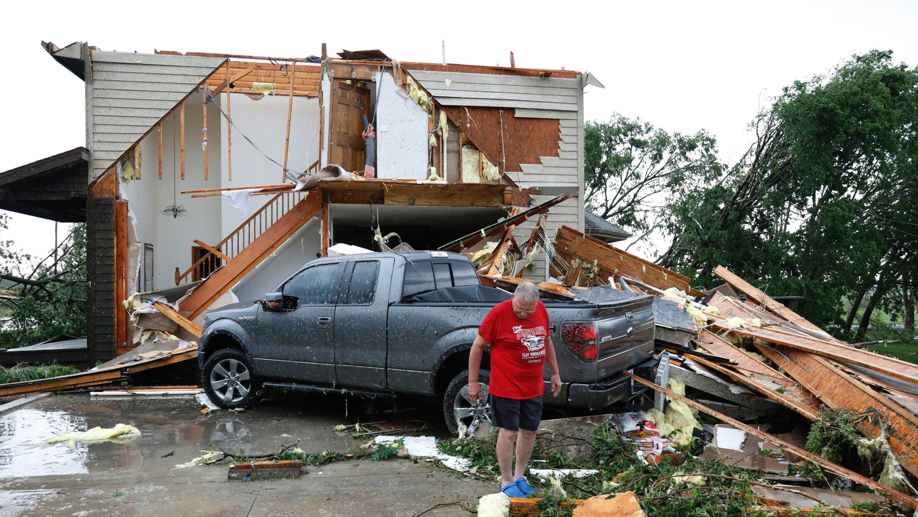 Joe Armison examines the damage done to his home after a tornado hit the suburbs of Eudora, Kansas on Tuesday, May 28, 2019. (AP Photo / Colin E. Braley)