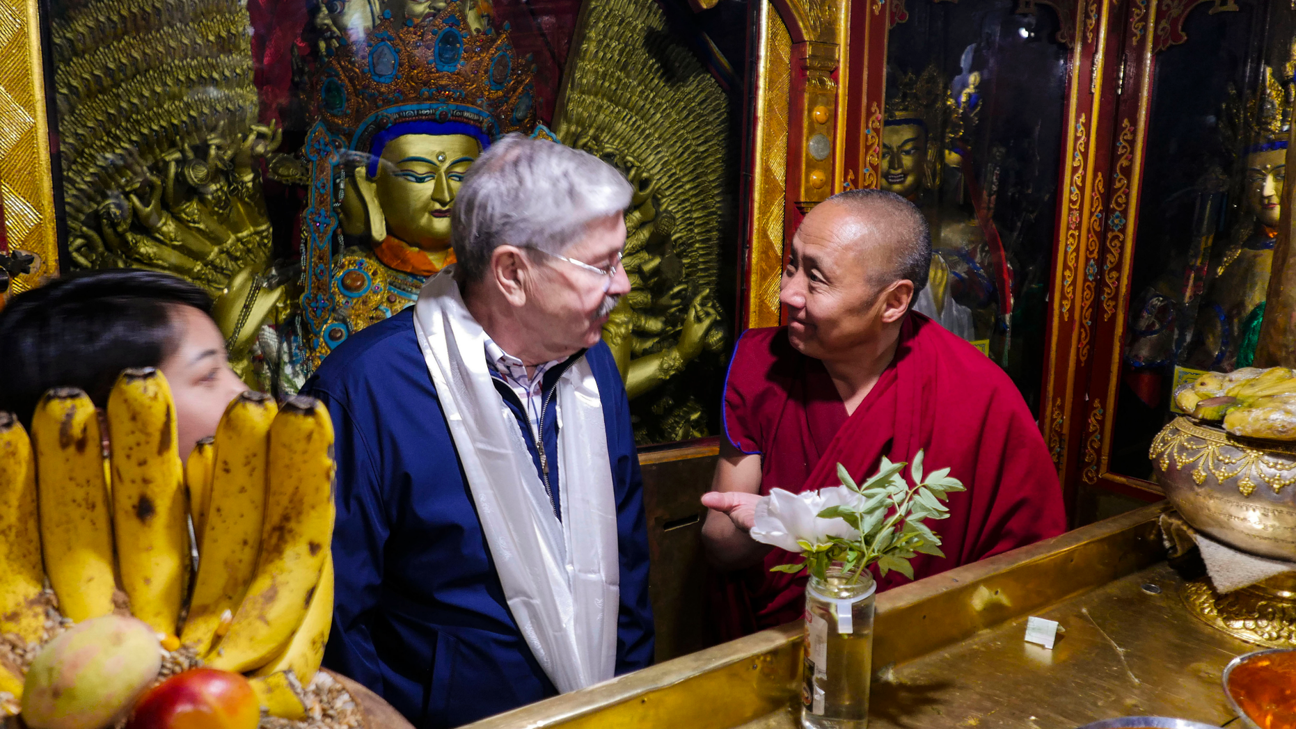 In this photo taken May 23, 2019, and released by the U.S. Embassy in Beijing, U.S. Ambassador to China Terry Branstad, left, speaks with a monk at the Jokhang Temple in Lhasa in western China's Tibet Autonomous Region. The U.S. ambassador to China urged Beijing to engage in substantive dialogue with exiled Tibetan Buddhist leader the Dalai Lama during a visit to the Himalayan region over the past week, the Embassy said Saturday. (U.S. Mission to China via AP)