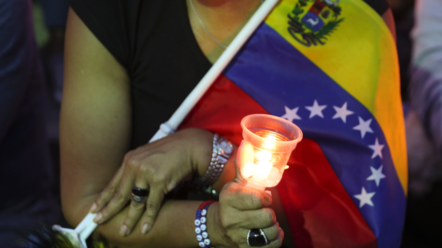 An opponent to Venezuela's President Nicolas Maduro holds a candle during a vigil for those killed in street fighting over the past week in Caracas, Venezuela, Sunday, May 5, 2019. Opposition leader Juan Guaid called in vain for a military uprising to overthrow President Nicolas Maduro, and five people were killed in clashes between protesters and police. (AP Photo/Martin Mejia)