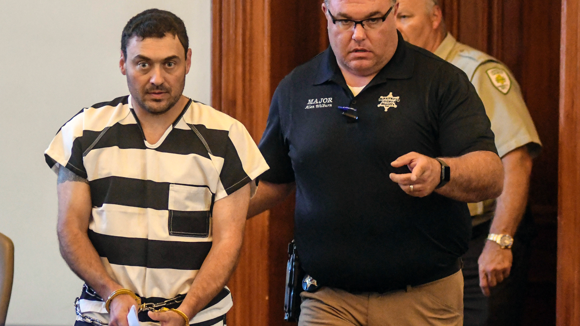 Oxford Police Officer Matthew Kinne, center, is escorted into a hearing by Lafayette County Sheriff Dept. Maj. Alan Wilburn at the Lafayette County Courthouse, Wednesday, May 22, 2019, in Oxford, Miss. Kinne is charged in the death of 32-year-old Dominique Clayton, who was found dead Sunday. (Bruce Newman/The Oxford Eagle via AP)