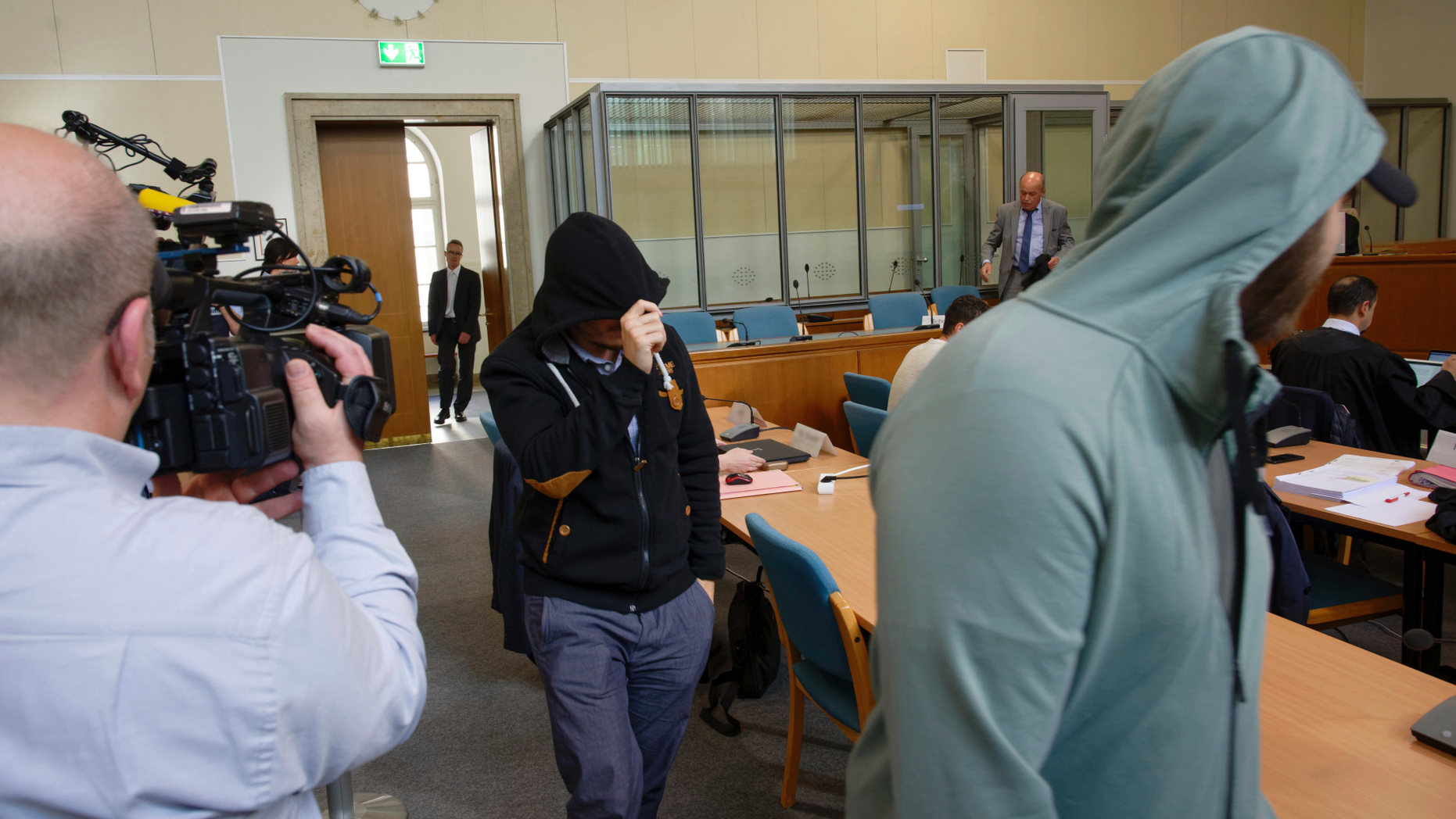In this Friday, May 24, 2019 file photo, two defendants of a self-styled 'Sharia police' arrive in a courtroom in Wuppertal, Germany. The court has found seven men who posed as a self-styled 'Sharia police' in the country, guilty on charges they violated rules on wearing uniforms and fined the men to penalties between 300 (335 dollars) and 1,800 (2010 dollars) euros. (Henning Kaiser/dpa via AP)