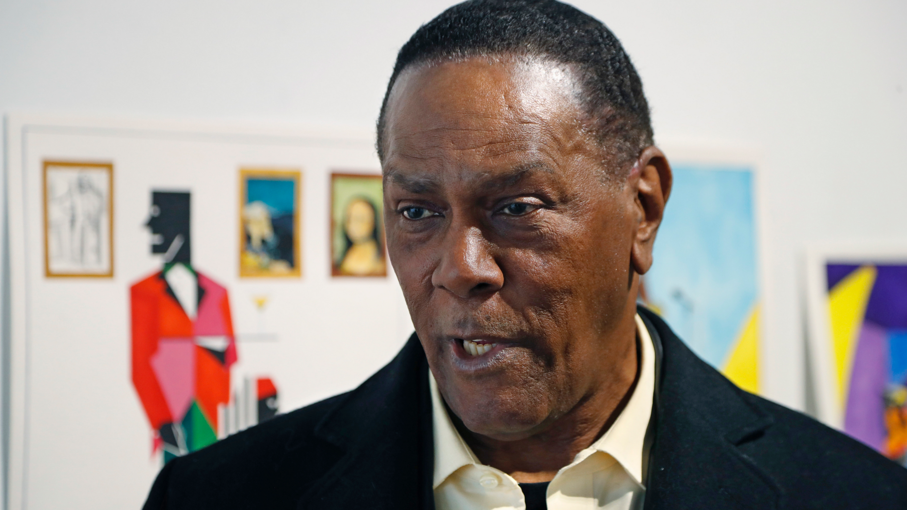 FILE - In this Jan. 17, 2019 file photo, Richard Phillips stands next to some of his artwork during an interview at the Community Art Gallery in Ferndale, Mich. Phillips was exonerated of murder in 2018 after 45 years in prison. The state of Michigan has agreed to pay $1.5 million to Phillips. The attorney general's office said Friday, May 17, 2019, it has settled a lawsuit filed Phillips. He made a claim under a Michigan law that compensates the wrongly convicted. (AP Photo/Carlos Osorio File)
