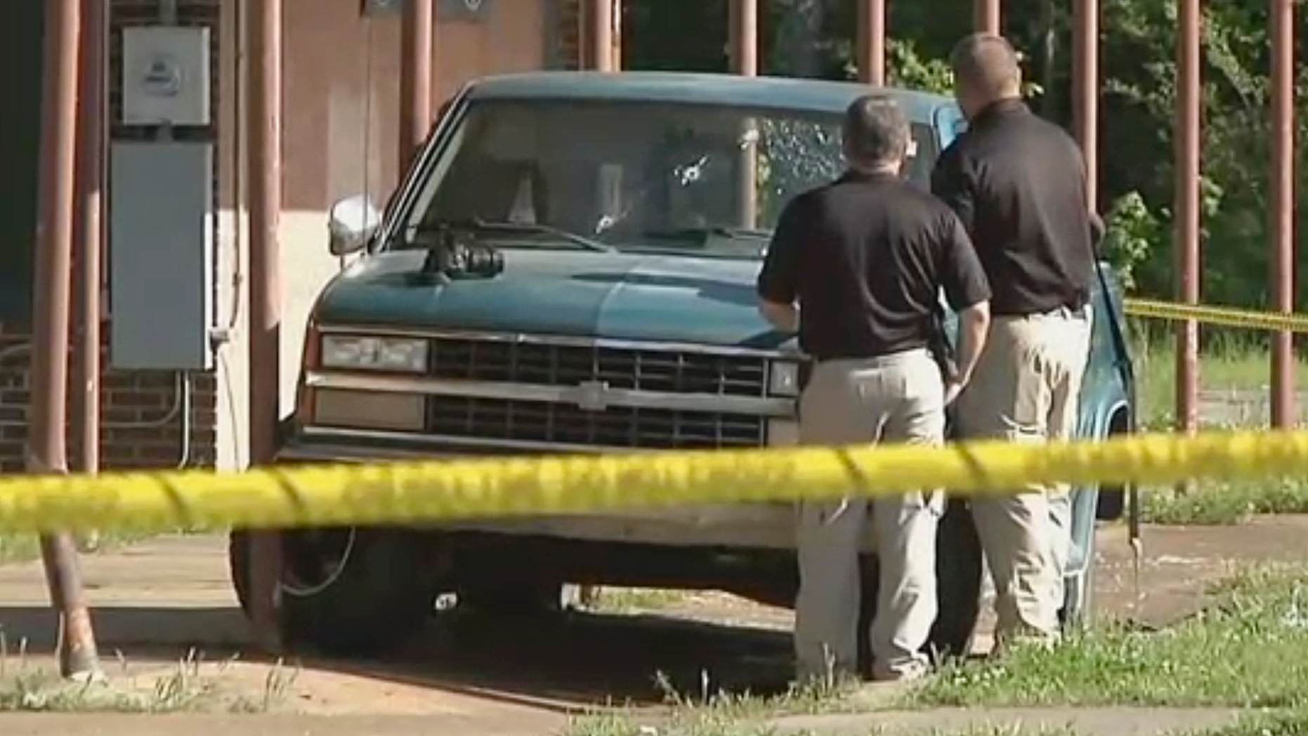 In this Friday, April 26, 2019 image made from video provided by KTEN, investigators inspect a pickup truck with bullet holes in its windshield in Hugo, Okla. Olivia Hill says Oklahoma police fired at William Devaughn Smith in the vehicle with her and her four children, with two of her kids suffering head wounds and another shot in the face. (KTEN via AP)
