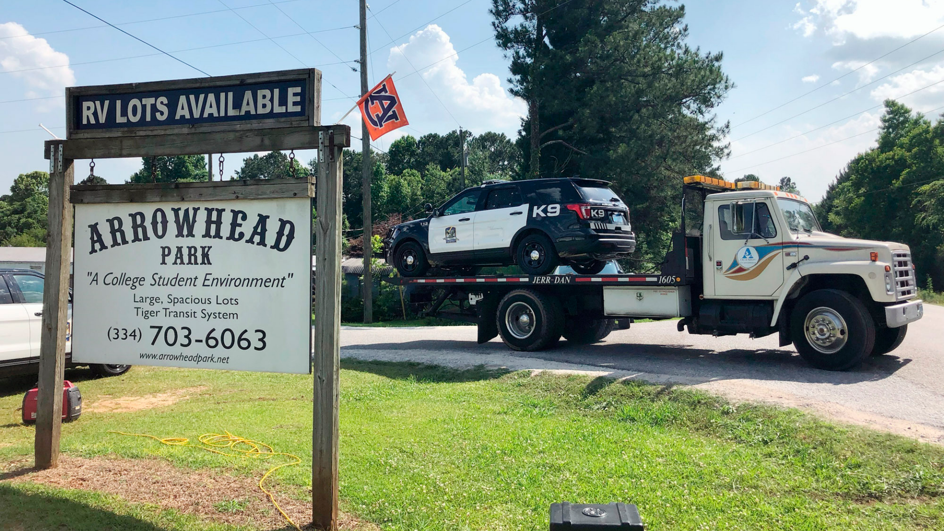 A tow truck removes a police car from a mobile home park, Monday, May 20, 2019, in Auburn, Ala., where three police officers were shot late Sunday. Authorities say a man opened fire on police responding to a domestic call late Sunday, killing one officer and wounding two others. (AP Photo/Blake Paterson)