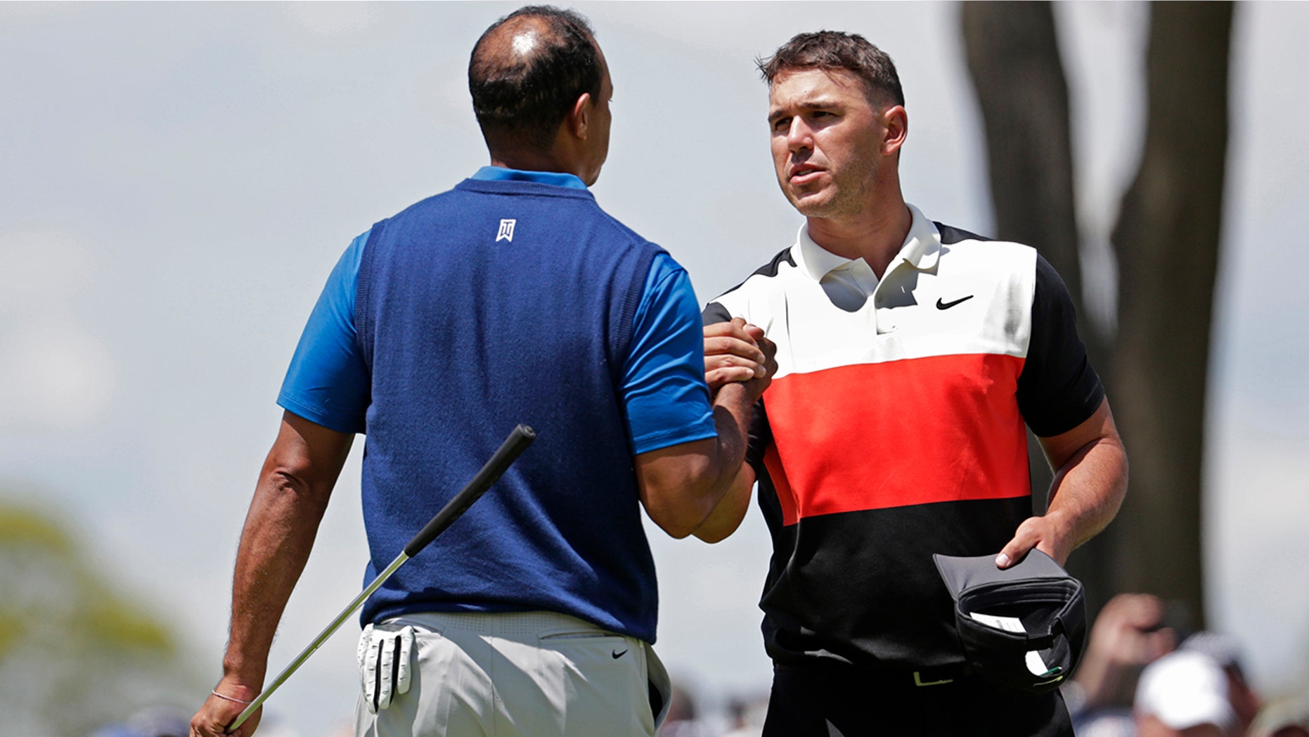 Brooks Koepka, right, shakes hands with Tiger Woods after finishing the first round of the PGA Championship golf tournament, Thursday, May 16, 2019, at Bethpage Black in Farmingdale, N.Y. (AP Photo/Julio Cortez)