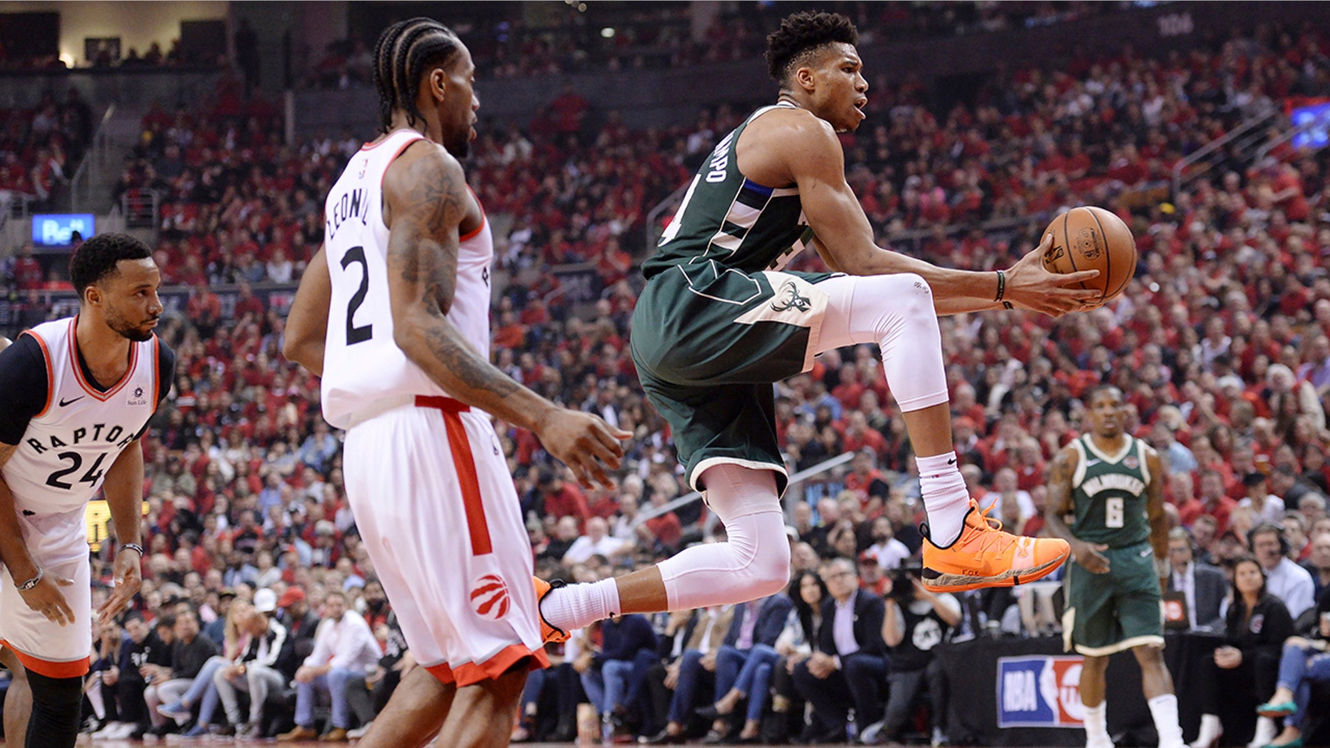 Milwaukee Bucks forward Giannis Antetokounmpo (34) drives to the net past Toronto Raptors forward Kawhi Leonard (2) during first half NBA Eastern Conference finals basketball action in Toronto on Sunday, May 19, 2019. (Nathan Denette/The Canadian Press via AP)