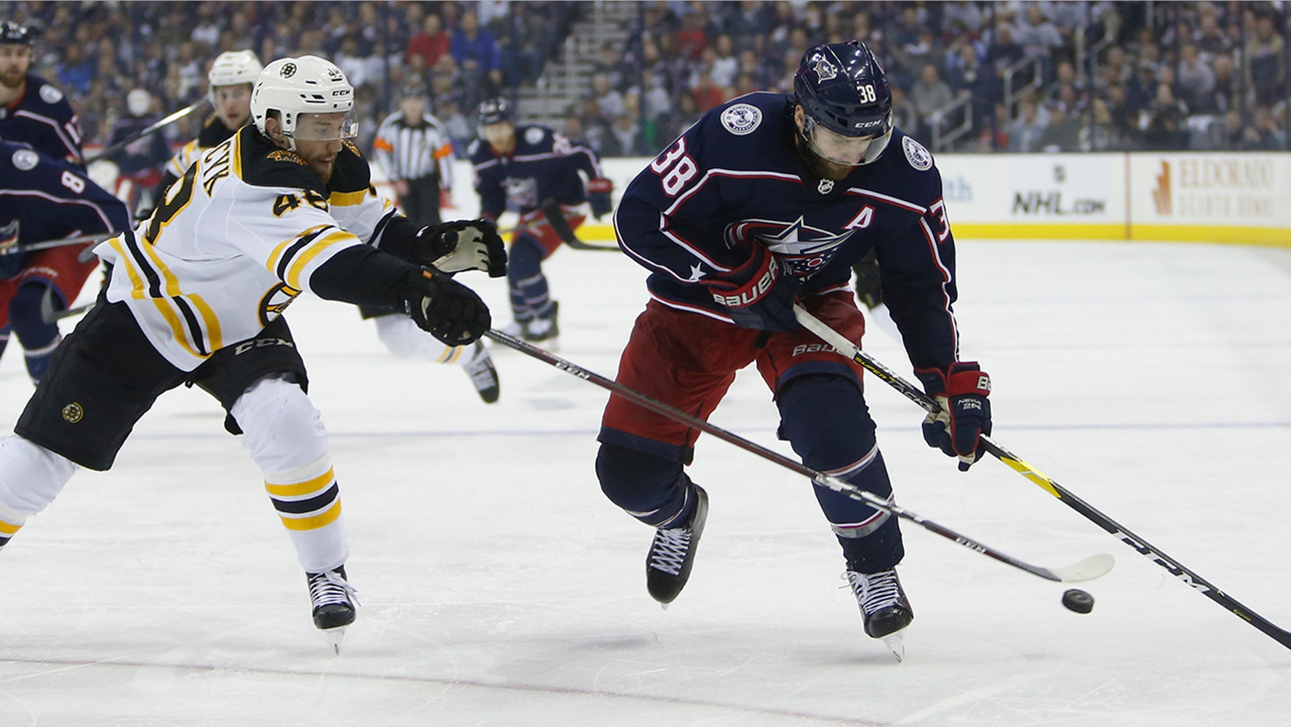 Columbus Blue Jackets' Boone Jenner, right, carries the puck up ice against Boston Bruins' Matt Grzelcyk during the second period of Game 3 of an NHL hockey second-round playoff series Tuesday, April 30, 2019, in Columbus, Ohio. (AP Photo/Jay LaPrete)