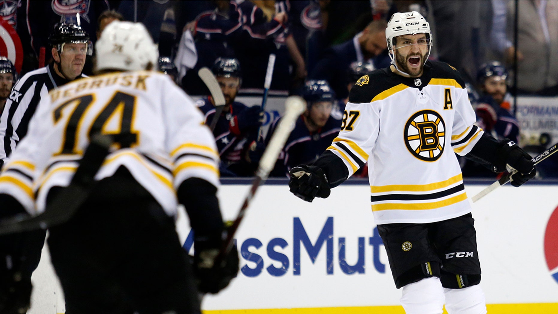 Boston Bruins forward Patrice Bergeron, right, celebrates his goal against the Columbus Blue Jackets with forward Jake DeBrusk during the first period of Game 4 of an NHL hockey second-round playoff series in Columbus, Ohio, Thursday, May 2, 2019. (AP Photo/Paul Vernon)