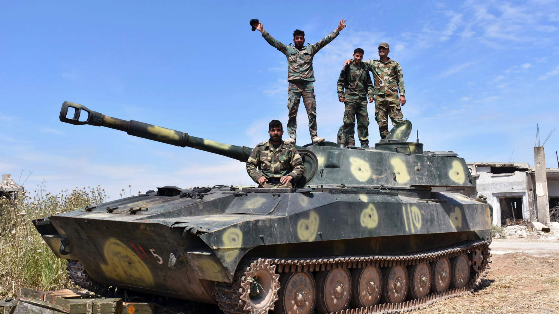 In this photo released by the Syrian official news agency SANA, Syrian army soldiers flash the victory sign as they stand on their tank in the village of Kfar Nabuda, in the countryside of the Hama province on Saturday, May 11, 2019. The Britain-based Syrian Observatory for Human Rights said government forces are now in control of nine villages forming an L shape at the far southern corner of the rebel stronghold. The villages include the strategic village of Kfar Nabuda and the elevated Qalaat Madiq, giving the government troops an advantage over the insurgents. (SANA via AP)