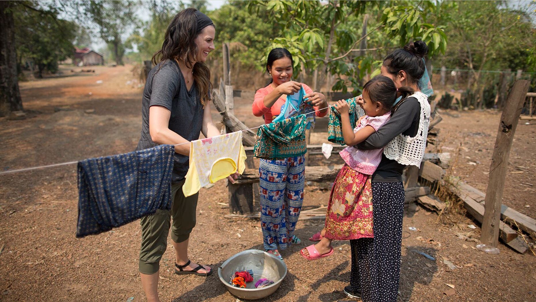 Cissie Graham Lynch works side by side with mothers in Kratie Province, Cambodia-- washing clothes and hearing about their families.