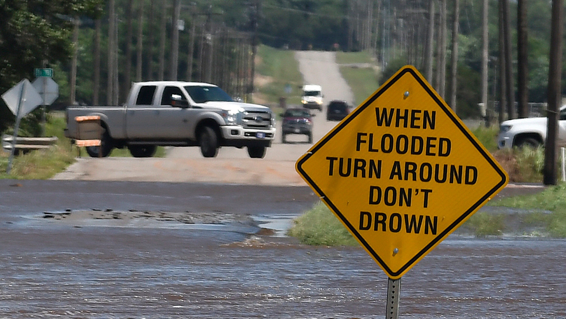 Traffic turns around as flood water covers 13th street in Kingfisher, Okla., Tuesday, May 21, 2019. (Billy Hefton/Enid News & Eagle via AP)