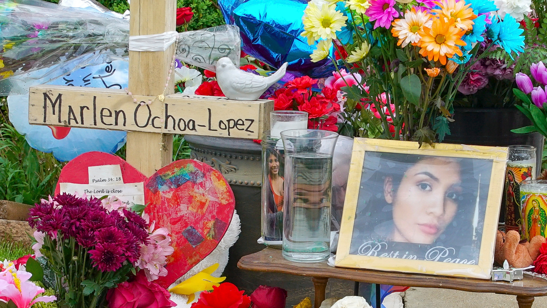 A memorial of flowers, balloons, a cross and photo of victim Marlen Ochoa-Lopez, are displayed on the lawn, Friday, May 17, 2019 in Chicago, outside the home where Ochoa-Lopez was murdered last month. Assistant State's Attorney James Murphy says a pregnant Ochoa-Lopez, who was killed and whose baby was cut from her womb, was strangled while being shown a photo album of the late son and brother of her attackers. (AP Photo/Teresa Crawford)
