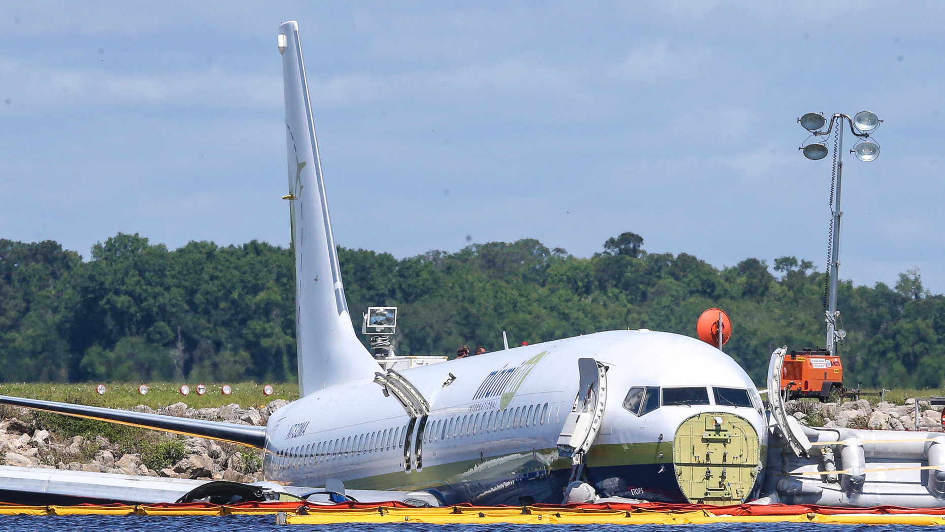 A charter plane carrying 143 people and traveling from Cuba to north Florida sits in a river at the end of a runway, Saturday, May 4, 2019 in Jacksonville, Fla. The Boeing 737 arriving at Naval Air Station Jacksonville from Naval Station Guantanamo Bay, Cuba, with 136 passengers and seven aircrew slid off the runway Friday night into the St. Johns River, a NAS Jacksonville news release said. (AP Photo/Gary McCullough)