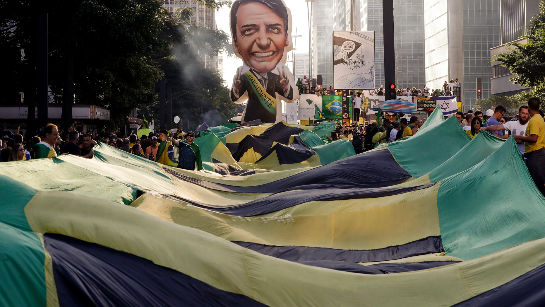 Supporters of Brazil's President Jair Bolsonaro feature a large, inflatable doll in his image as they demonstrate along Paulista Avenue in Sao Paulo, Brazil, Sunday, May 26, 2019. The pro-Bolsonaro rally follows anti-government protests against education budget cuts as the president also battles an uncooperative Congress, a family corruption scandal and falling approval ratings after five months in office. (AP Photo/Andre Penner)