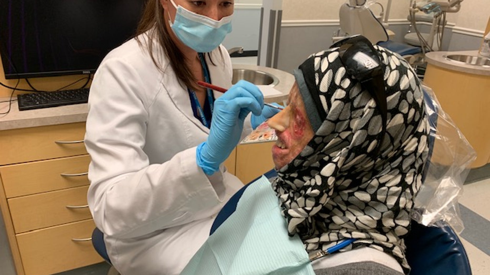 Syrian burn victim Hamama offers a rare smile as she is fitted for a new prosthetic nose by UCLA's Dr. Christine Fortmann in Los Angeles, CA.