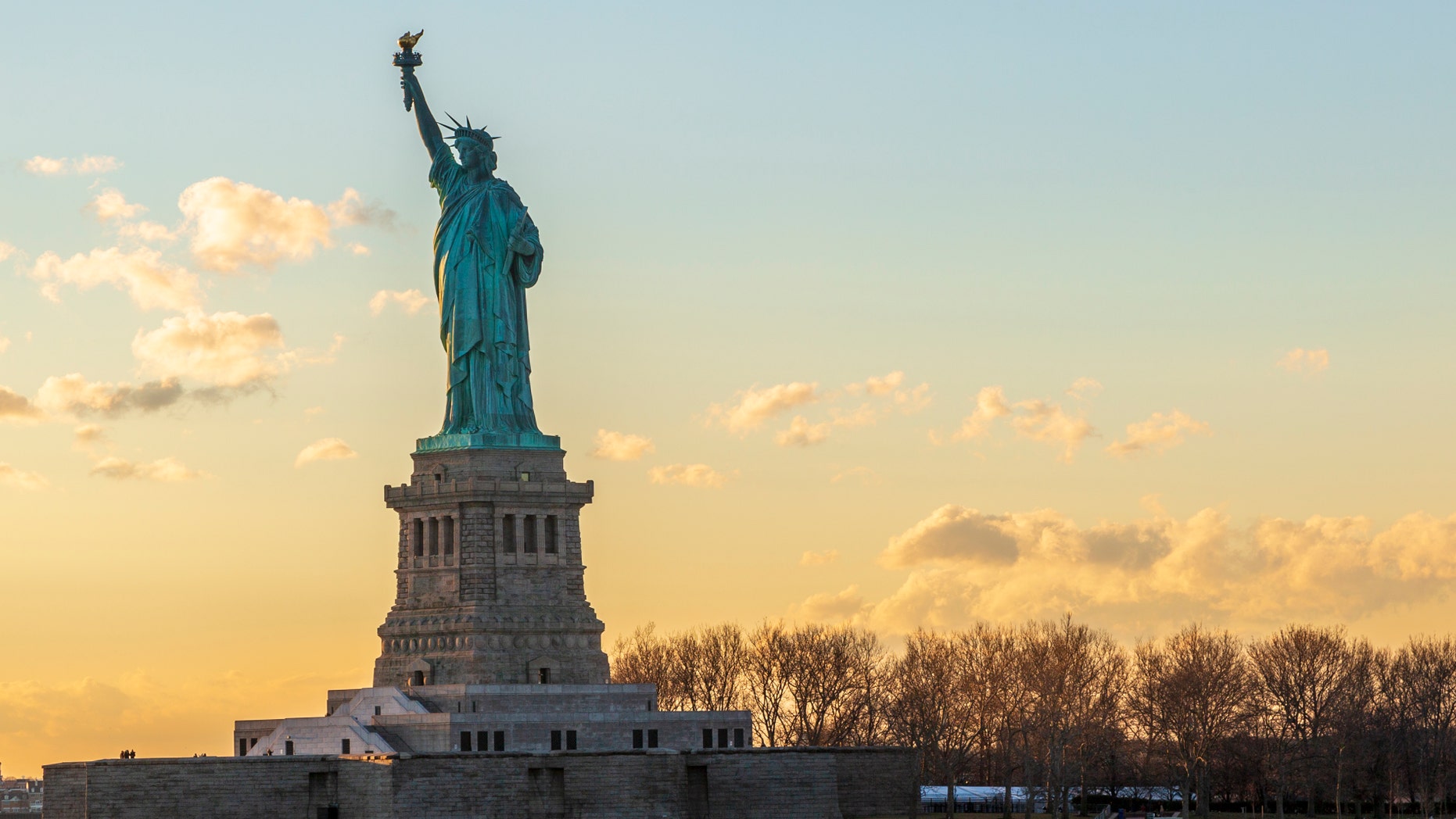 Statue of liberty horizontal during sunset in New York City, NY, USA