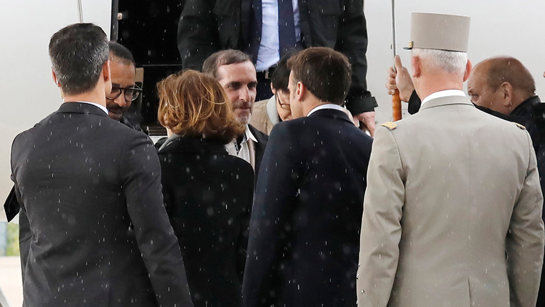 Freed French hostages Laurent Lassimouillas, left, and Patrick Picque, 2nd right, are welcomed by French President Emmanuel Macron, right, and Defense and Minister Florence Parly, 2nd left, at Villacoublay's military airport, west of Paris, France, Saturday, May 11, 2019. Officials said two French special forces officers and four 