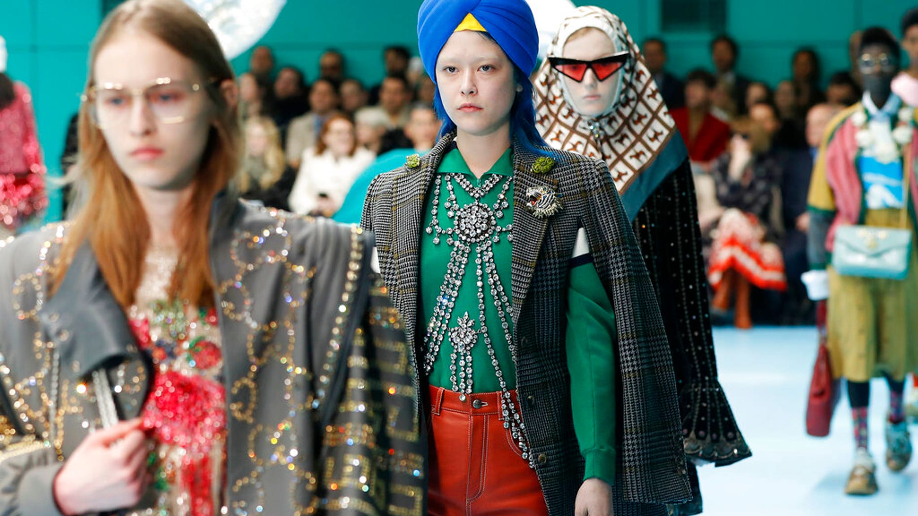FILE - In this Feb. 21, 2018 file photo, models display items from Gucci's women's Fall/Winter 2018-2019 collection, presented during the Milan Fashion Week, in Milan, Italy. The top civil rights organization for Sikhs in the United States says Nordstrom has apologized to the community for selling an $800 turban they found offensive, but they are still waiting to hear from the Gucci brand that designed it, Saturday, May 18, 2019. (AP Photo/Antonio Calanni, File)
