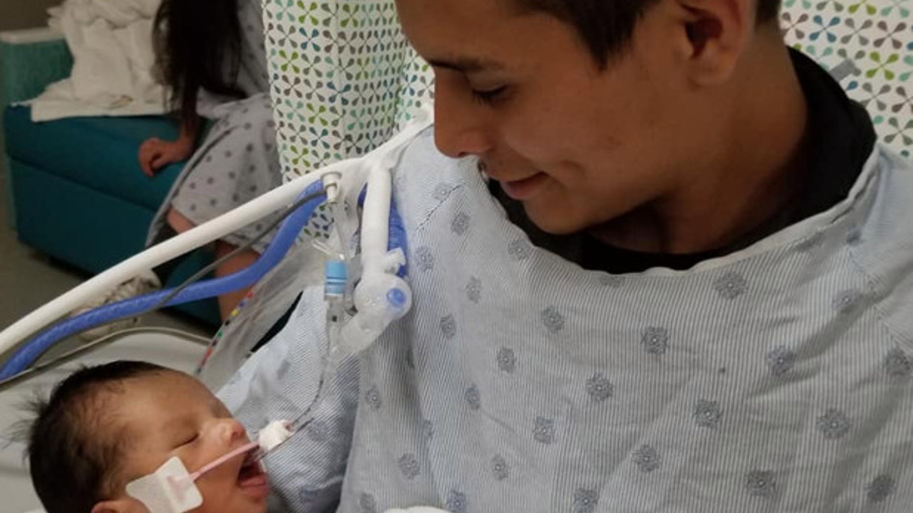 This photo shared on social media shows Yovani Lopez holding his newborn son.